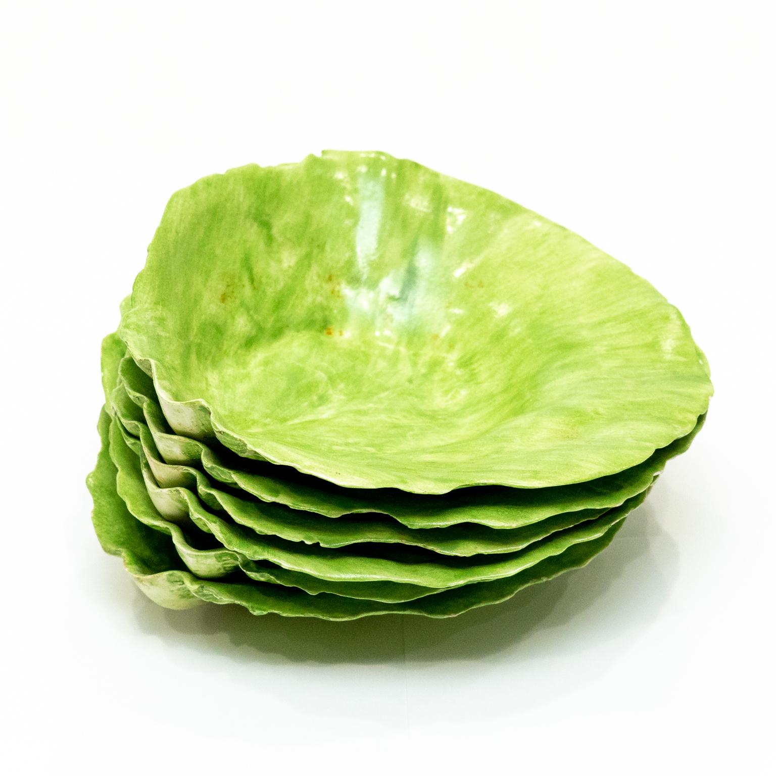 Circa 1970s set of six painted lettuceware or cabbage leaf-shaped plates in the Palm Beach Regency style. Made in the United States. Please note of wear consistent with age. One dish has a very fine pin paint chip. Could have restorations but well