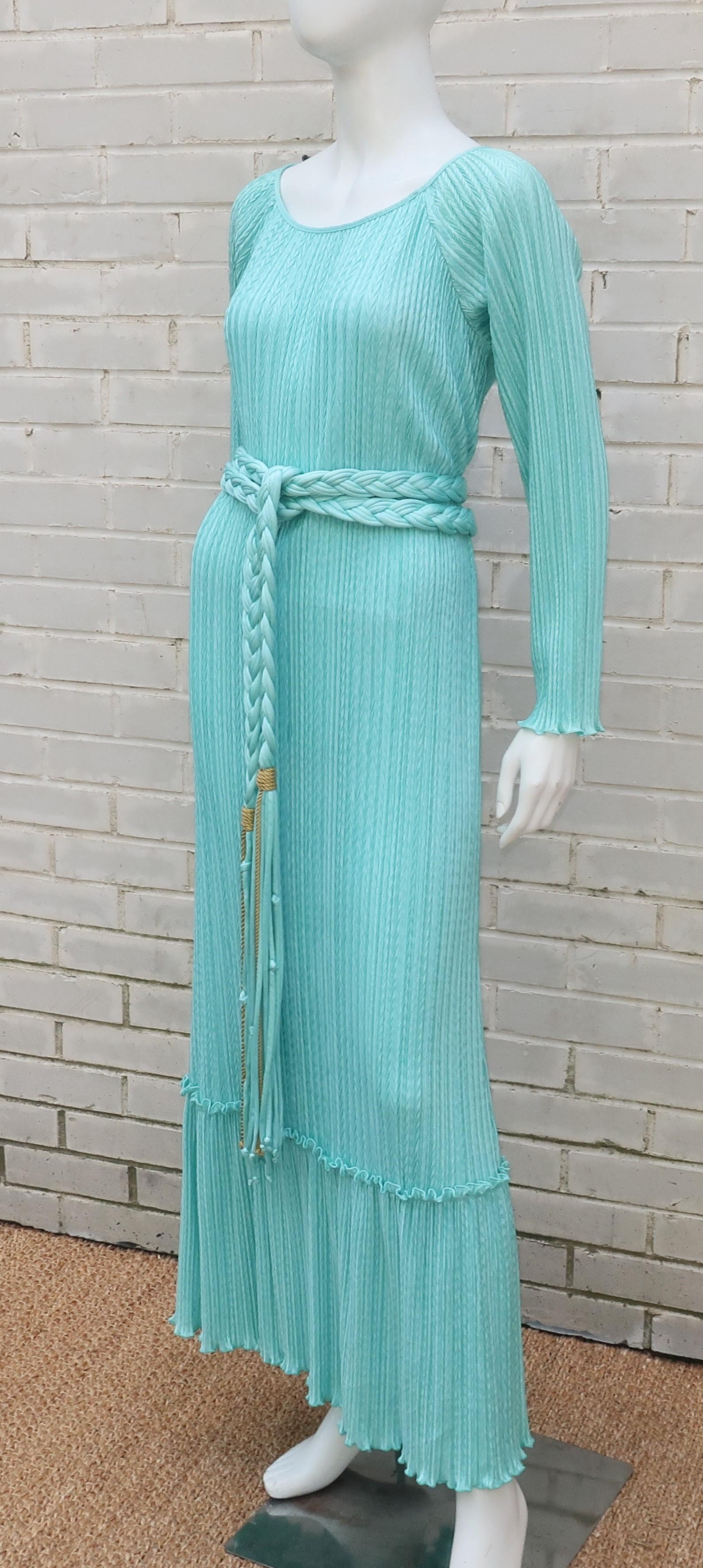Mary McFadden creates a fabulous look for lounging or hostess wear with this aqua goddess dress in her signature micro pleated fabric with an added chevron style design.  The pullover construction features an open neckline and a tiered hem.  The