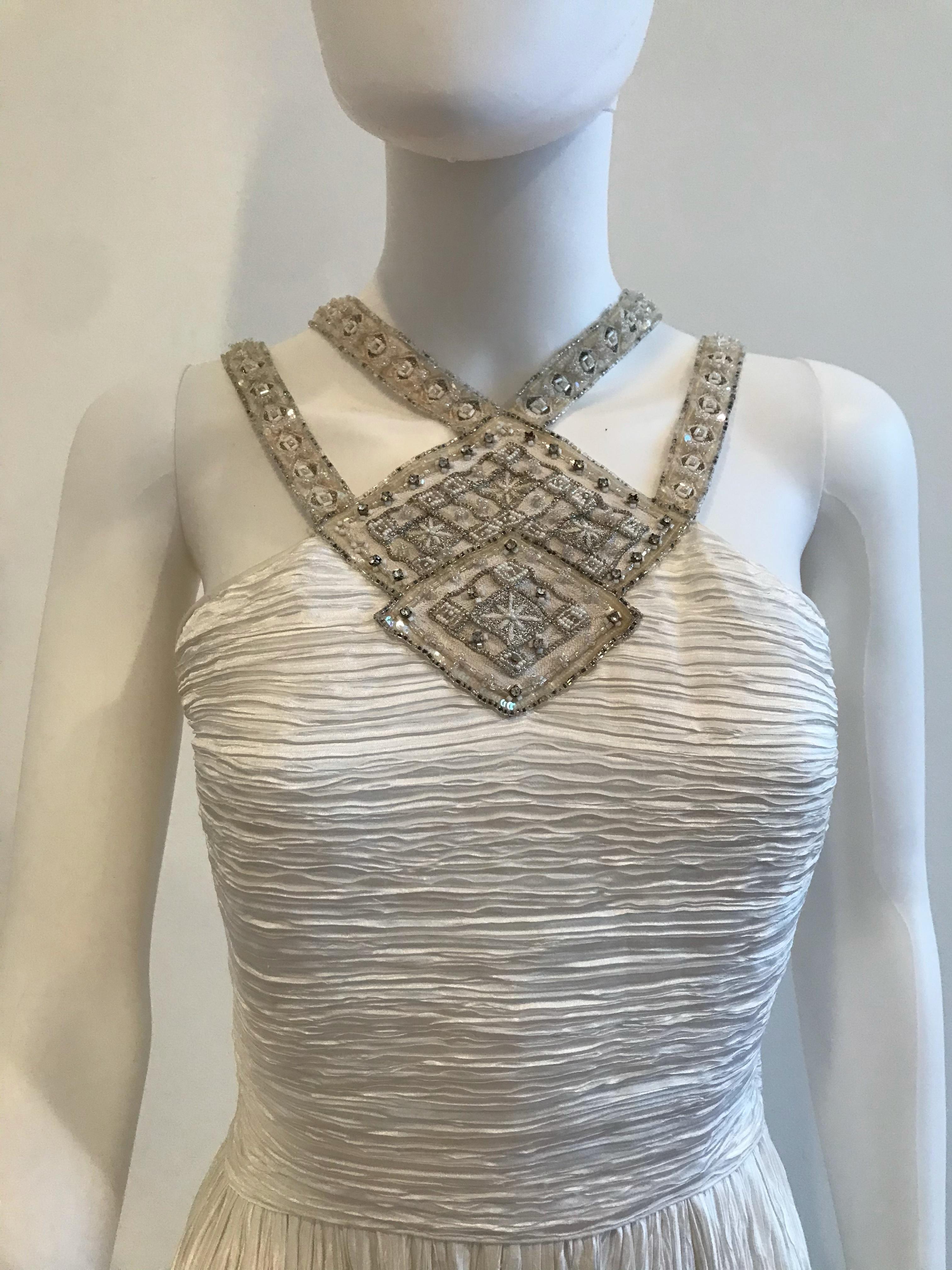 Ikonisches weißes Mary McFadden-Kleid. Dieses zarte und elegante Kleid hat eine Criss-Cross-Perlenverzierung auf der Vorderseite, die einen Neckholder bildet und sich bis zur hinteren Taille fortsetzt. Hergestellt in den USA. Größe US 8.