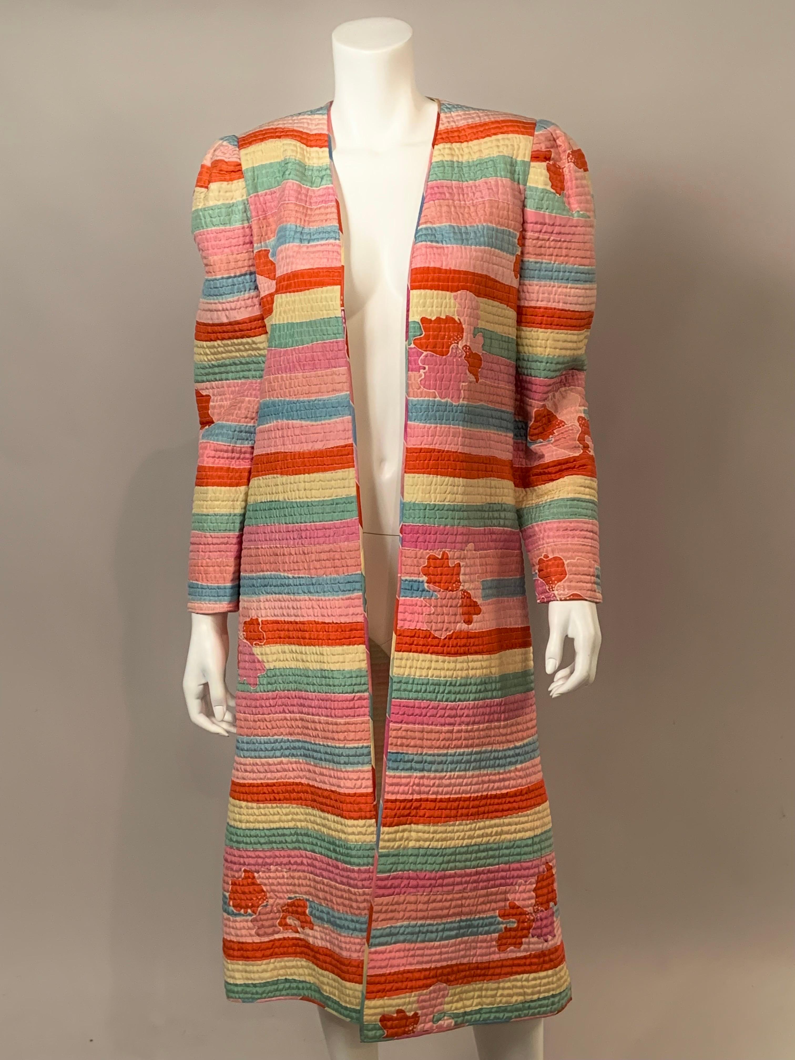 This is such a cheerful and versatile coat designed by Mary McFadden in the 1980's.  The fabric is a luscious striped silk in shades of pink, yellow rose, green, blue and orange.  Abstract floral bouquets are scattered across the stripes.  It is