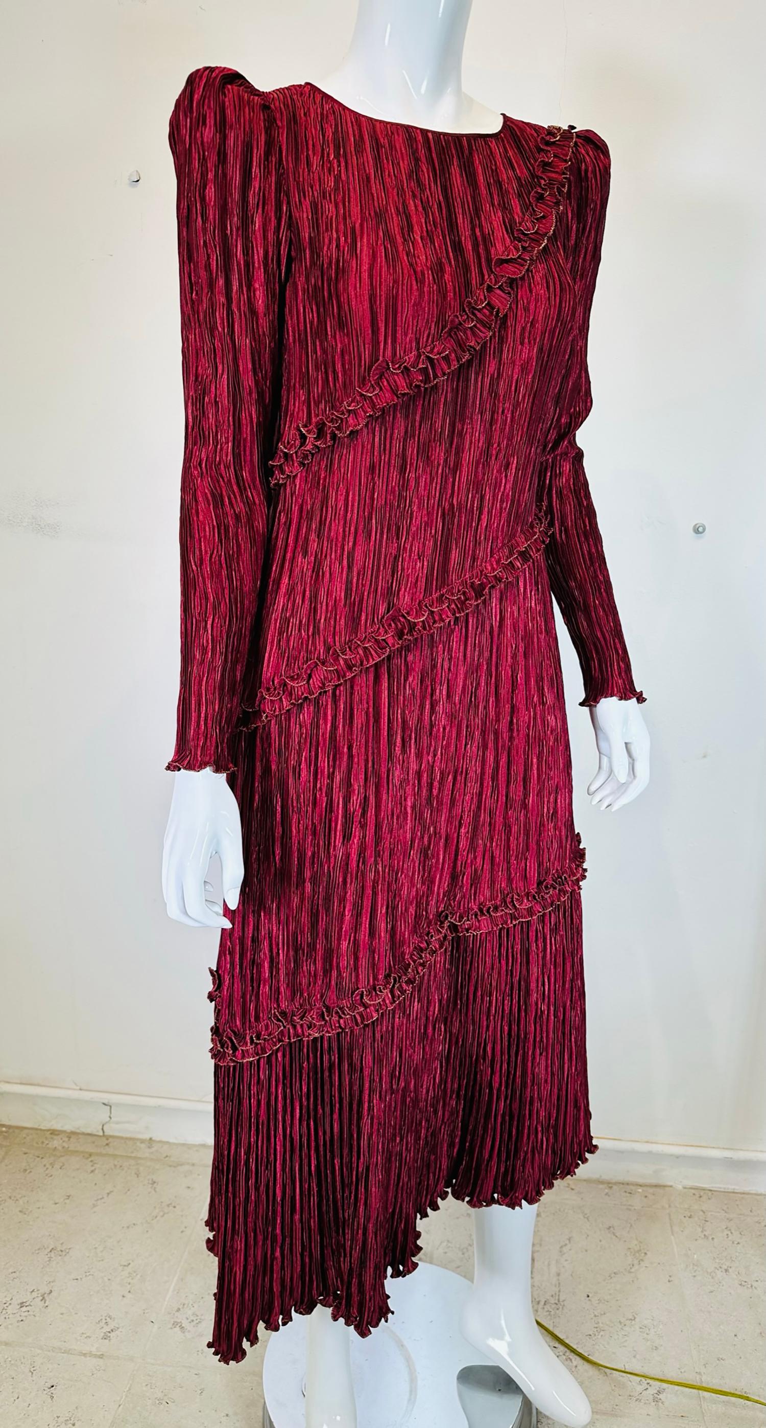 Mary McFadden garnet & gold pleated, peaked shoulder asymmetrical hem dress from the 1970s. Famous for her interpretation of Mario Fortuny's magically pleated silk gowns done in the early 1900s, Mary McFadden made her pleats permanent, which in may