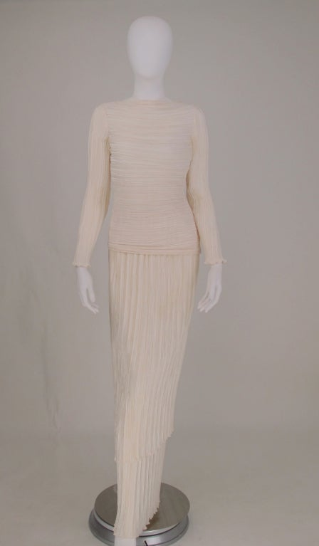 Mary McFadden Fortuny style pleated tiered evening dress from the 1980s. This dress consists of three parts, the top is long sleeved with deeply draped back and asymmetrical hem that closes at the side with a zipper.  The under skirt has a sheer