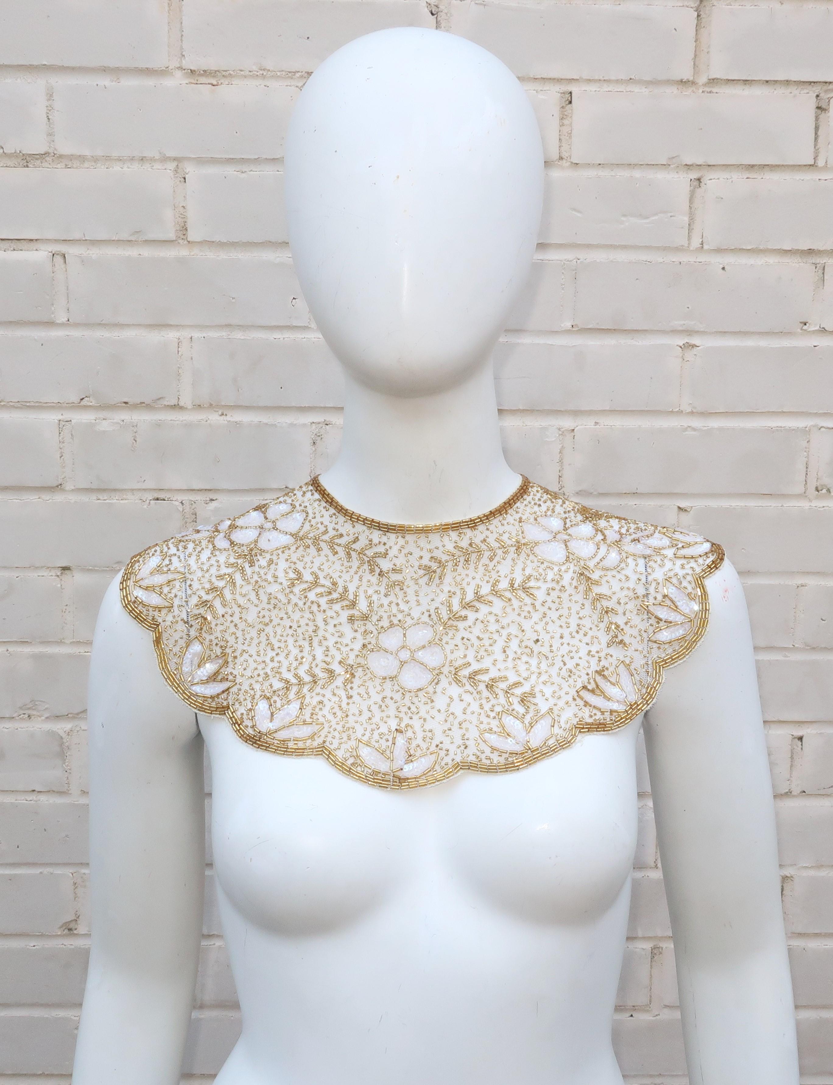 This beautiful Mary McFadden collar is a combination of exotic style and an ethereal look.  The netted candlelight white base has a scallop shape edge with an intricate floral pattern of gold bugle beads and iridescent sequins.  It hooks at the back