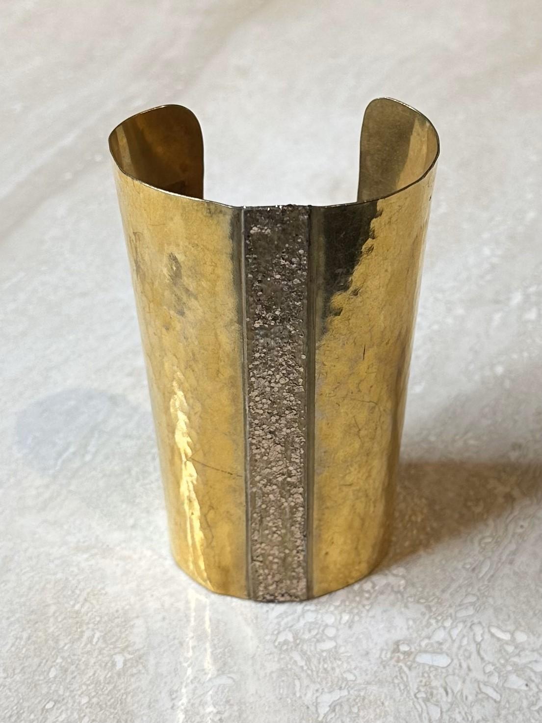 Le bracelet à manchette en or de Mary McFadden est un bijou époustouflant qui reflète l'amour de la créatrice pour les influences mondiales, les designs audacieux et l'élégance intemporelle. Son design large et haut lui confère une présence