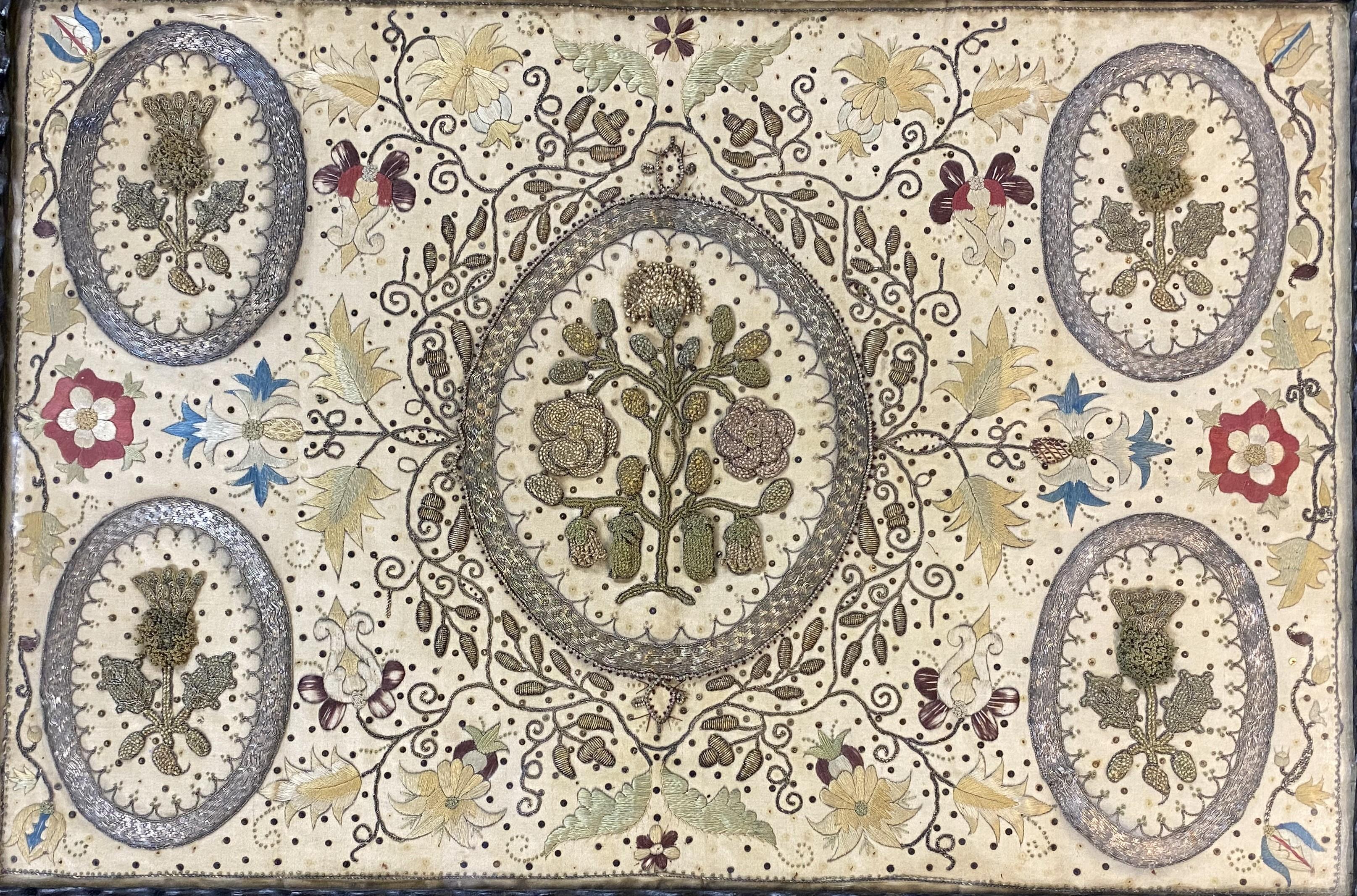 A wonderful example of Mary Stuart (Mary, Queen of Scots) hand wrought commemorative embroidery with a central foliate cartouche surrounded by four smaller ones, each with metallic thread and accented with colorful foliate background silk and metal
