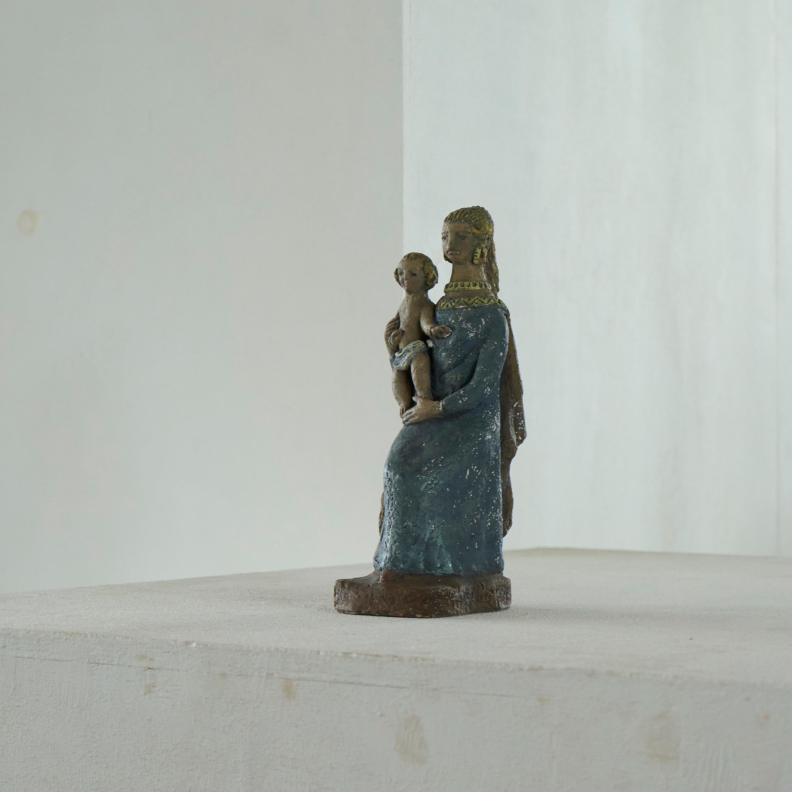 Maria mit Kind Skulptur aus Ton Anfang des 20. Jahrhunderts.

Schöne und etwas seltsame Skulptur, die Maria und Jesus in handbemaltem Ton darstellt. Tolle Farben und Ausdrücke - etwas surrealistisch und naiv, aber gerade das macht diese Skulptur so