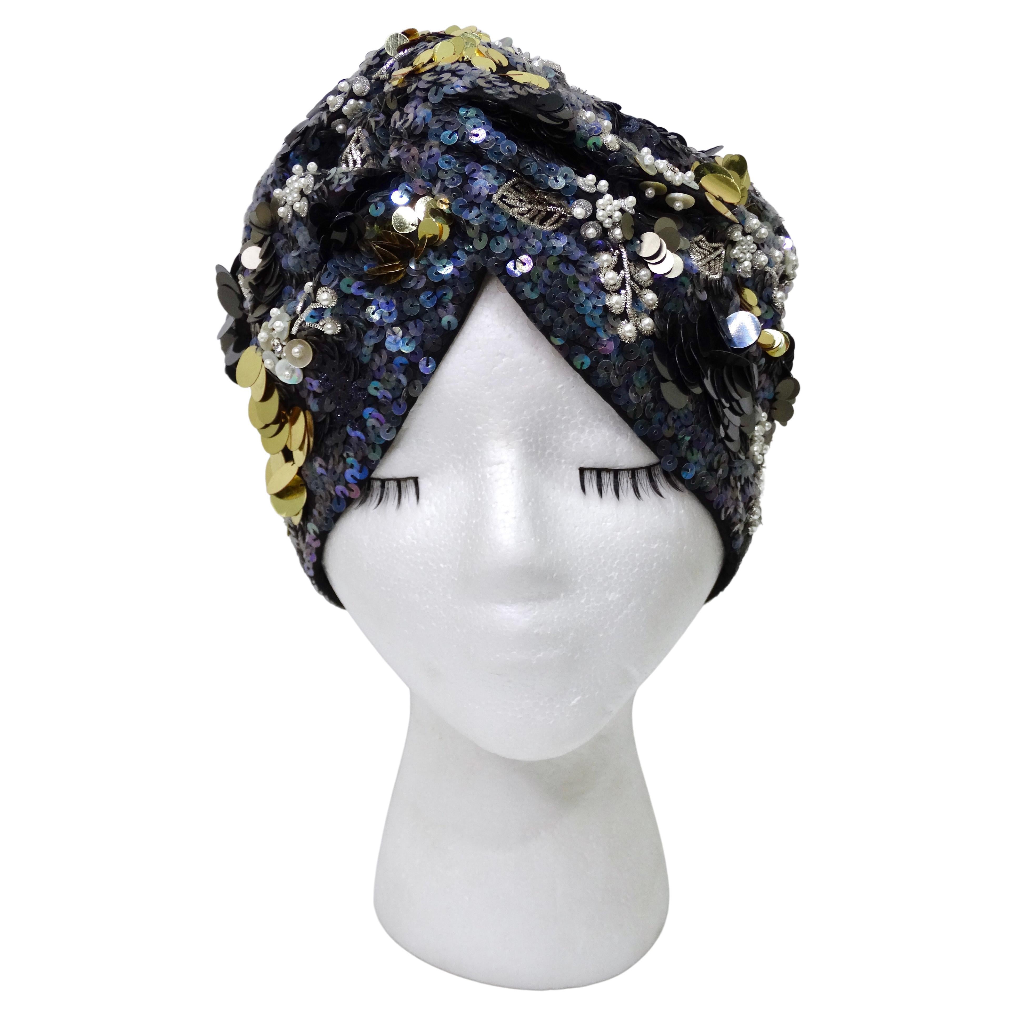 This is a beautiful and highly detailed turban by Maryjane Claverol featuring complete embellishing with large and small sequins and beading in soft colors like blue, grey, gold, and white. This will add interest and a statement to any outfit!