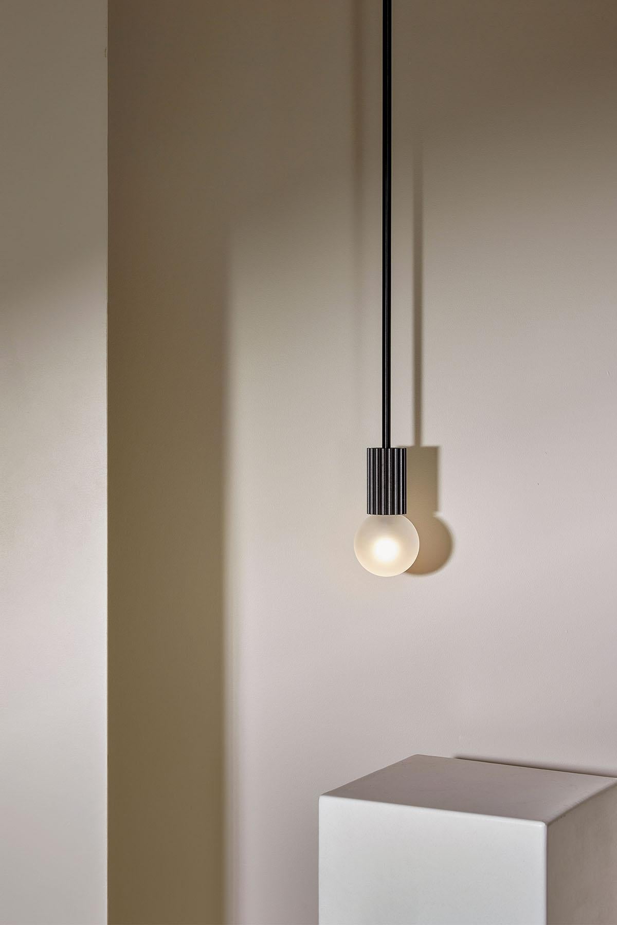La lampe suspendue Attalos, 95 est une lampe LED classique et sculpturale. Chaque pièce de la gamme Attalos s'inspire des colonnes cannelées de la Stoa d'Attalos, à Athènes, et de l'ordre dorique. La lampe suspendue Attalos est dotée d'un globe