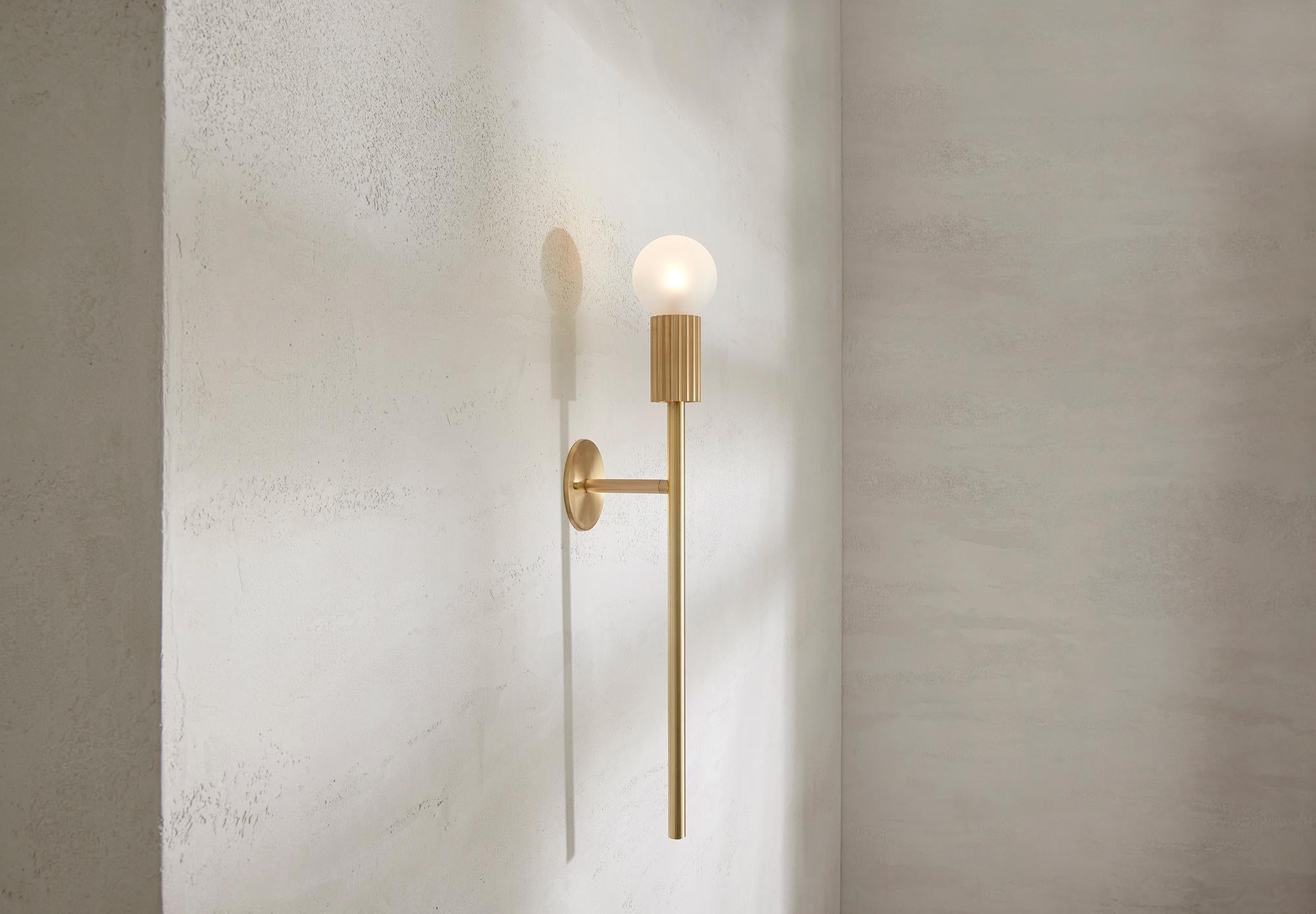 The Attalos Wall Light, 95 is a new addition to the current Attalos range and retains its classical sculptural aesthetic echoing ancient Greek architectural forms. Incorporating an LED frosted globe counterbalanced on a base and post machined from