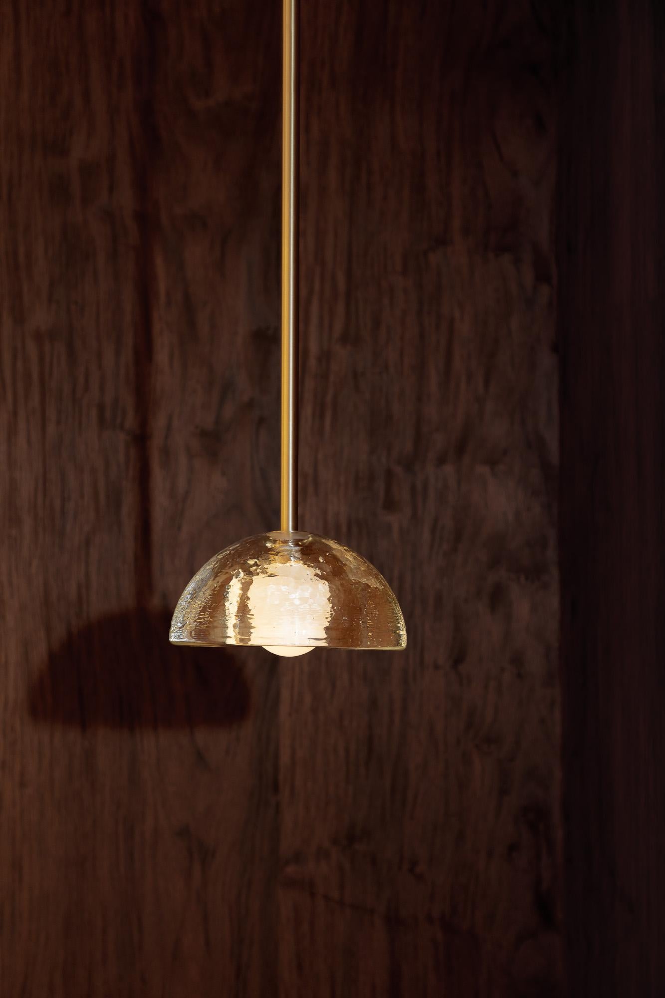 La lampada a sospensione Aurelia è realizzata a mano presso la prestigiosa Jam Factory di Adelaide, in Australia. Questo paralume semplice ma intricato si illumina attraverso il vetro con le bolle, creando un effetto gelatinoso unico nel suo genere.