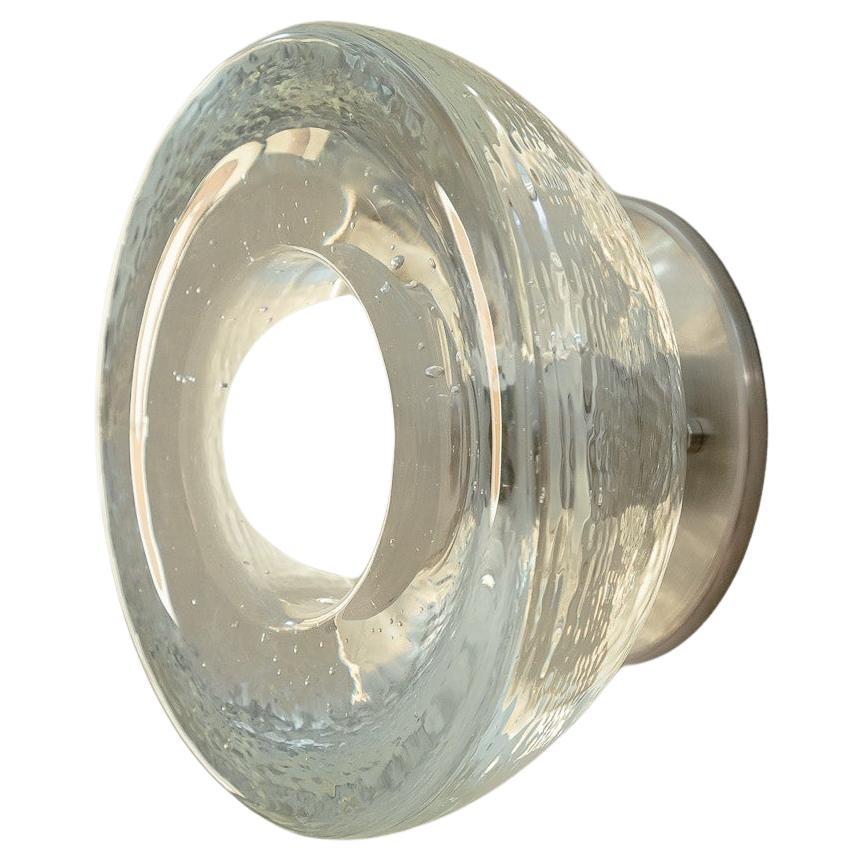 L'Aurelia Surface Sconce è fusa a mano nella prestigiosa Jam Factory di Adelaide, in Australia. Questo paralume semplice ma intricato si illumina attraverso il vetro con le bolle, creando un effetto gelatinoso unico nel suo genere. L'Aurelia Surface