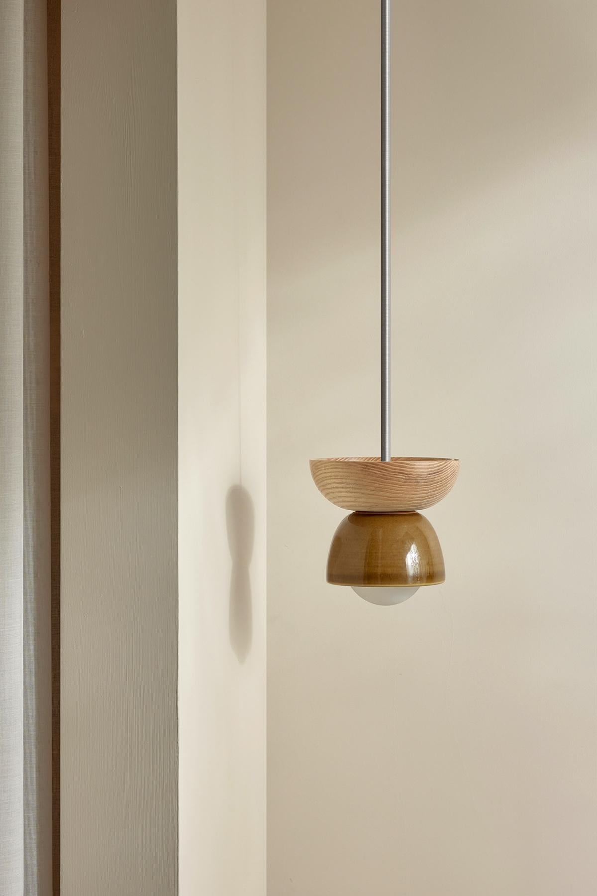 Elaborada con una combinación de dos medias cúpulas en contraste, Terra 00 está disponible en formatos de lámpara colgante, de pared y de techo. La lámpara colgante Terra 00 se compone de una pantalla de cerámica moldeada en barbotina, combinada con