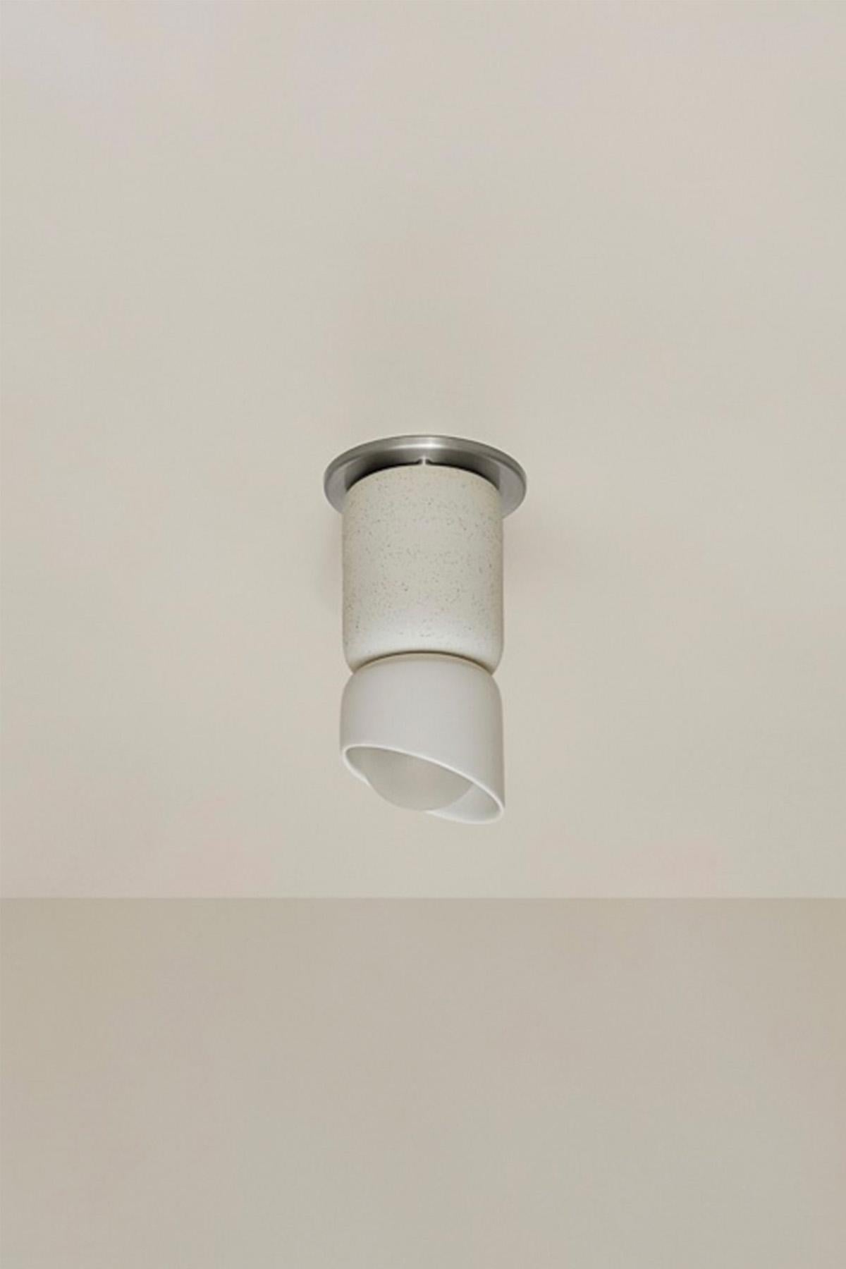 Le plafonnier Terra 1,5, Slim Base Adapter est un cylindre mat superposé et une base émaillée qui crée un empilement asymétrique de formes en céramique avec deux finitions contrastées. Disponible dans un choix de six tons naturels - gousse de