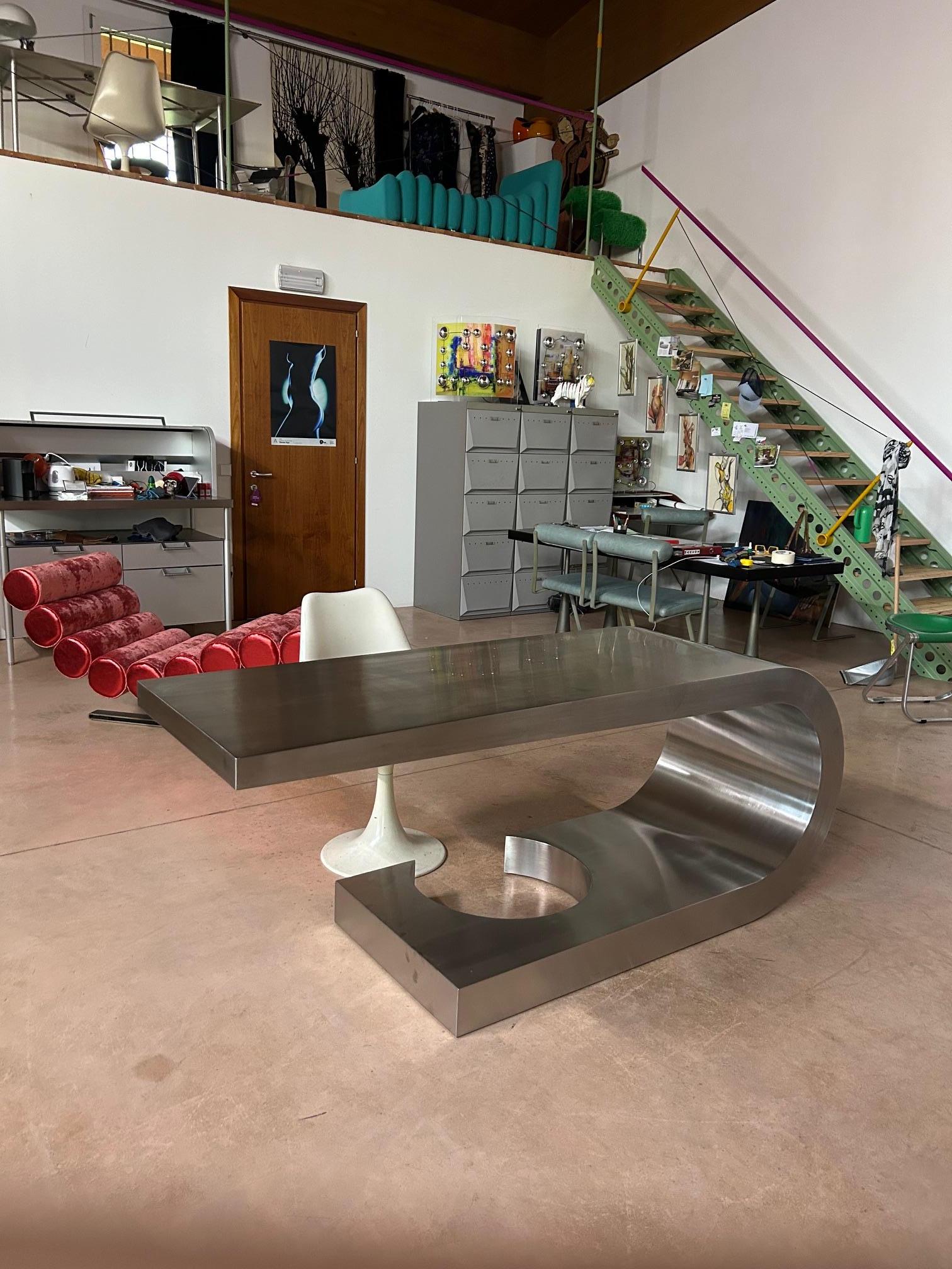 Iconic desk one of only 40 made designed by Marzio Cecchi and manufactured by Studio Most, Italy 1968. This stainless-steel desk has a cantilevered tapering top with curved edge and circular cut-out base where you can leave your feet. The desk is