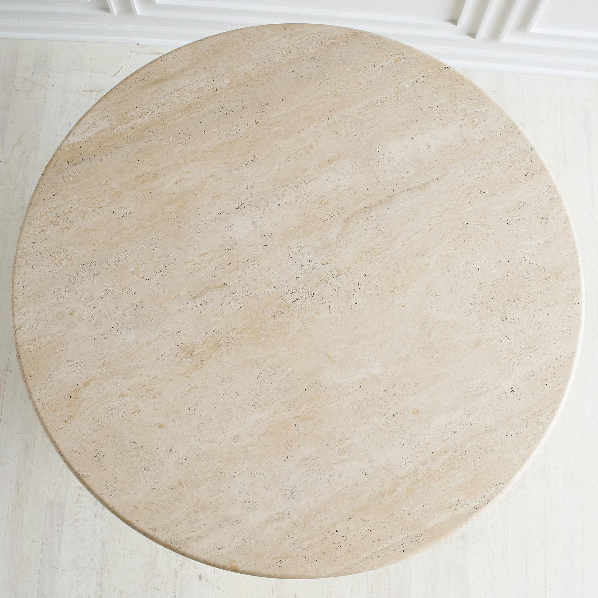 A remarkable dining table designed by Marzio Cecchi for Studio Most in honed travertine. Thick circular travertine discs with brass rings in between supporting a thick travertine tabletop with a full bullnose edge. 

The tabletop is positioned on