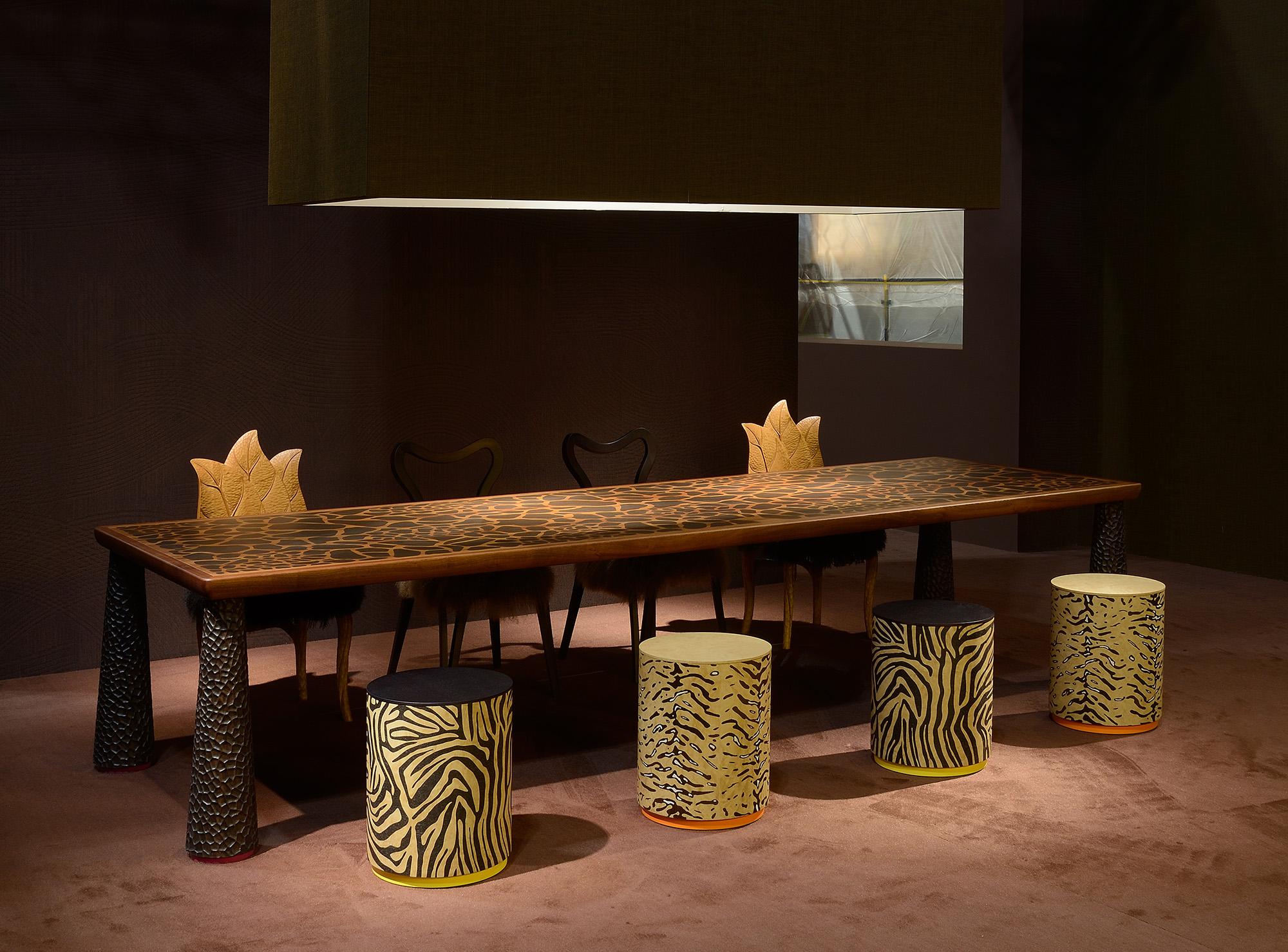 The Masai Dining Table is adorned with a mesmerizing giraffe inlay on the top and a solid mahogany frame, bringing a touch of the wild into your dining space. The giraffe finish adds a unique and luxurious character to the tabletop, making every