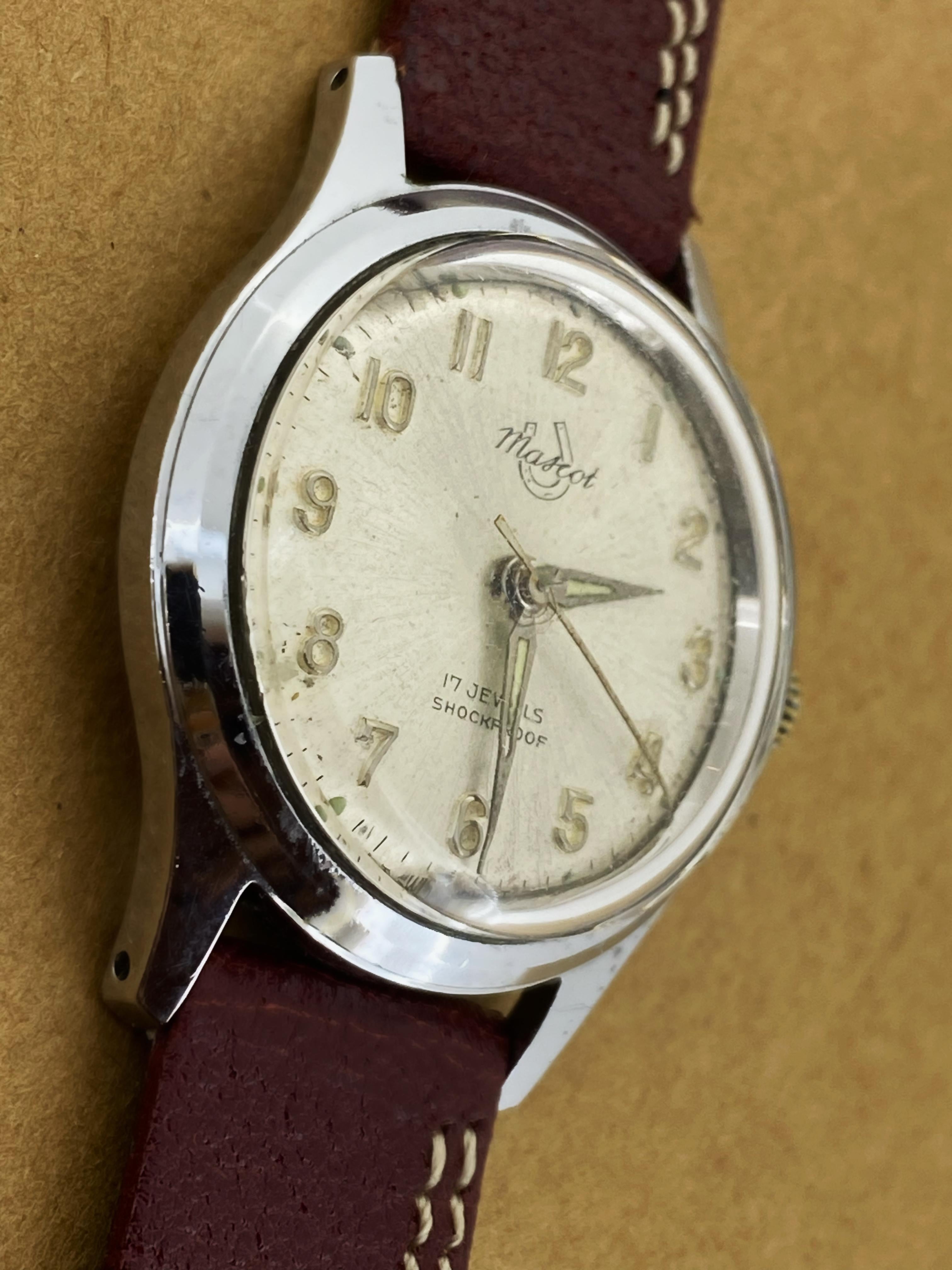 This elegant retro wristwatch in unisex, 
dating back to 1950’s & featuring: 

32mm Stainless Steel Case, 
signed to the back, 
water-resistant, shockproof & dustproof 

Silver coloured Dial with visually-striking & 
sought-after sunburst