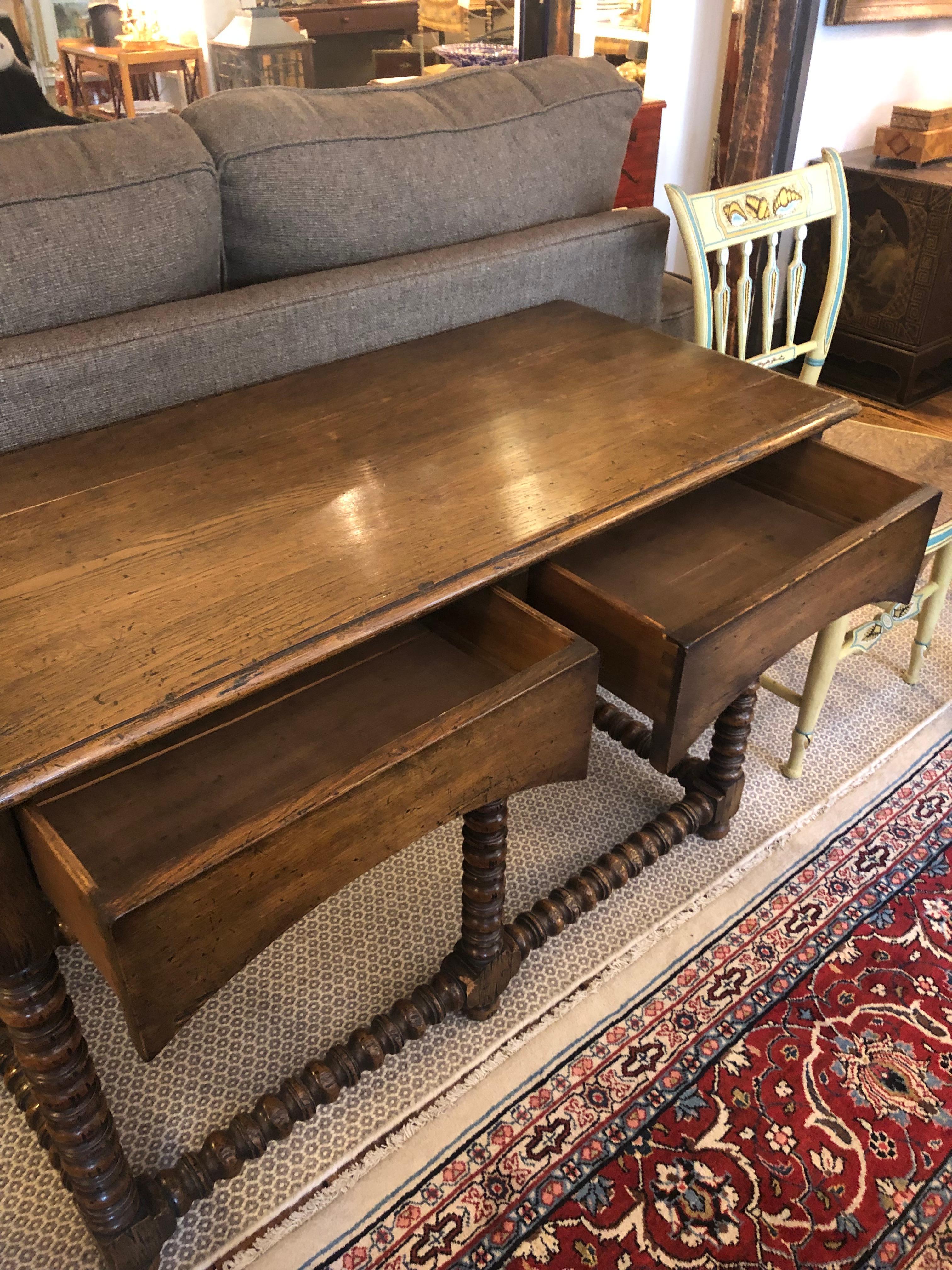 Very handsome masculine rich oak console having two drawers, finished front and back, and beautiful barley twist base. Makes a great table behind a sofa.