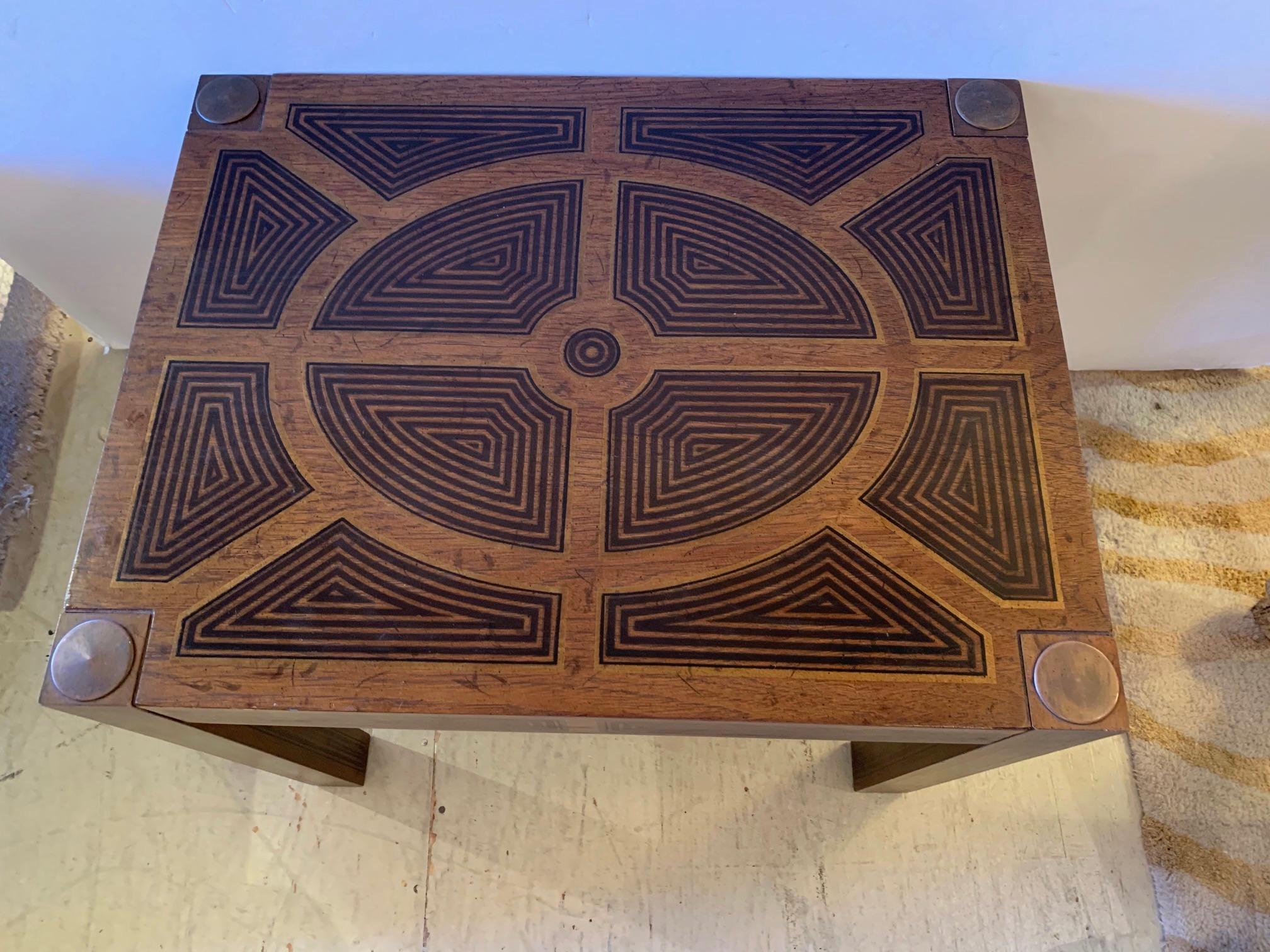 Handsome rectangular inlaid wood end table having stunning geometric design and brass medallions in each corner on top of square legs that are equally decorative.