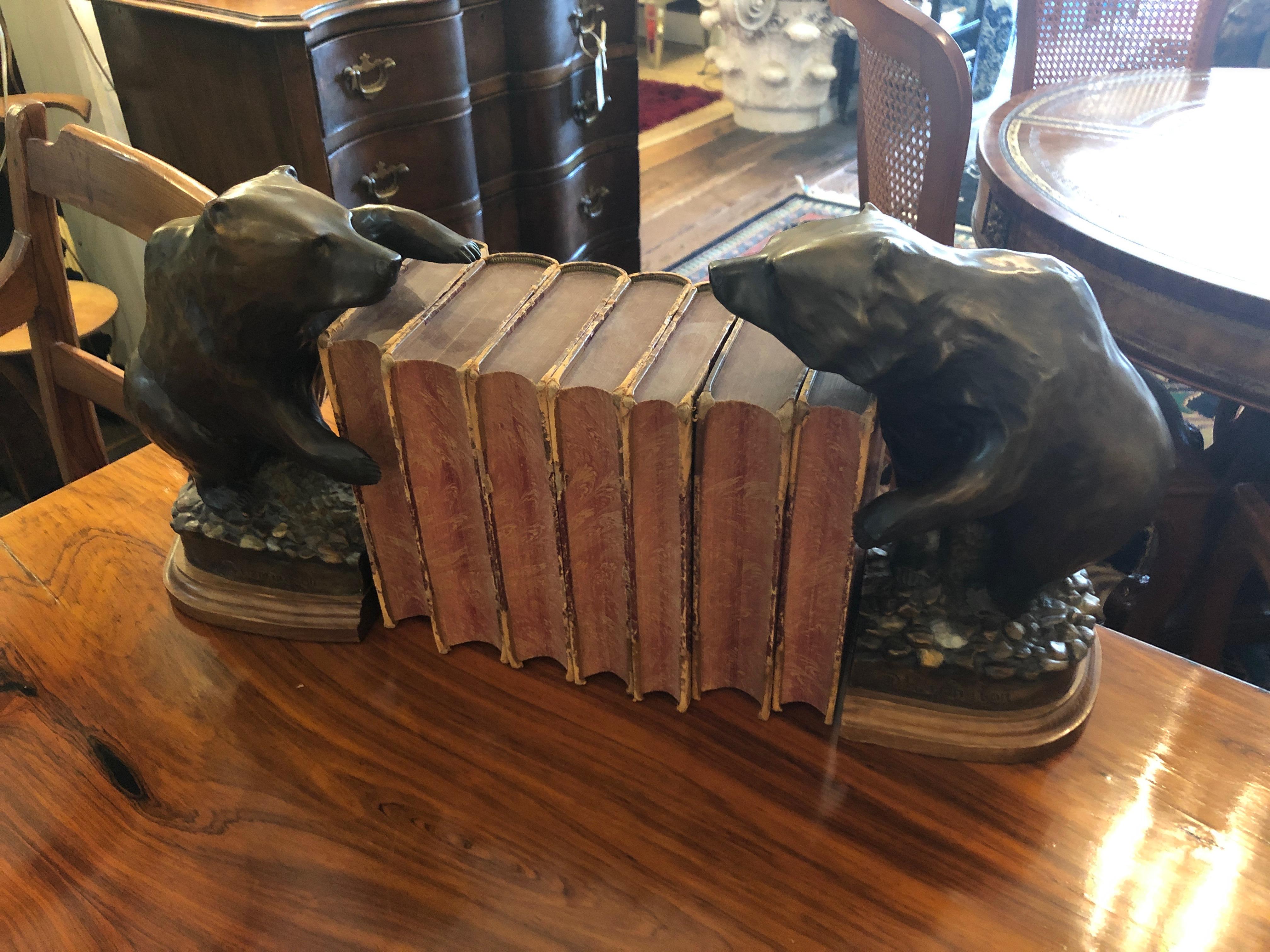 Handsome bronze bookends with wooden bases that are heavy masculine sculptures of bears in unique poses.