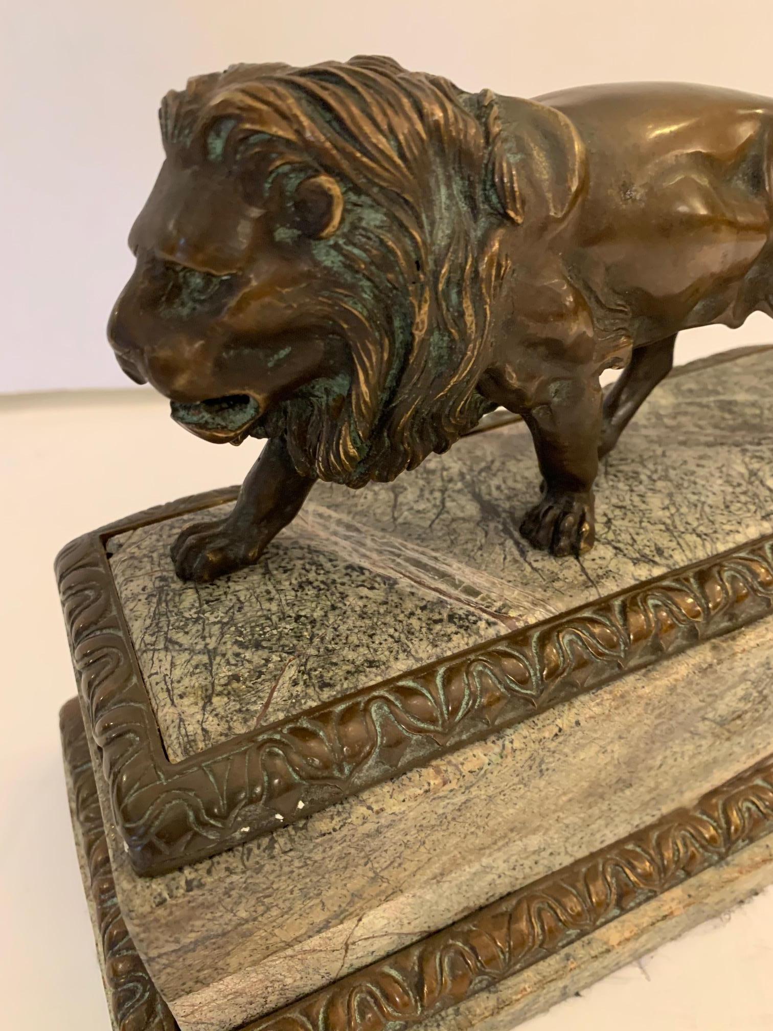 Beautiful tabletop objet d' art that's a mighty bronze lion in stride mounted on a nice chunk of marble with bronze decoration.