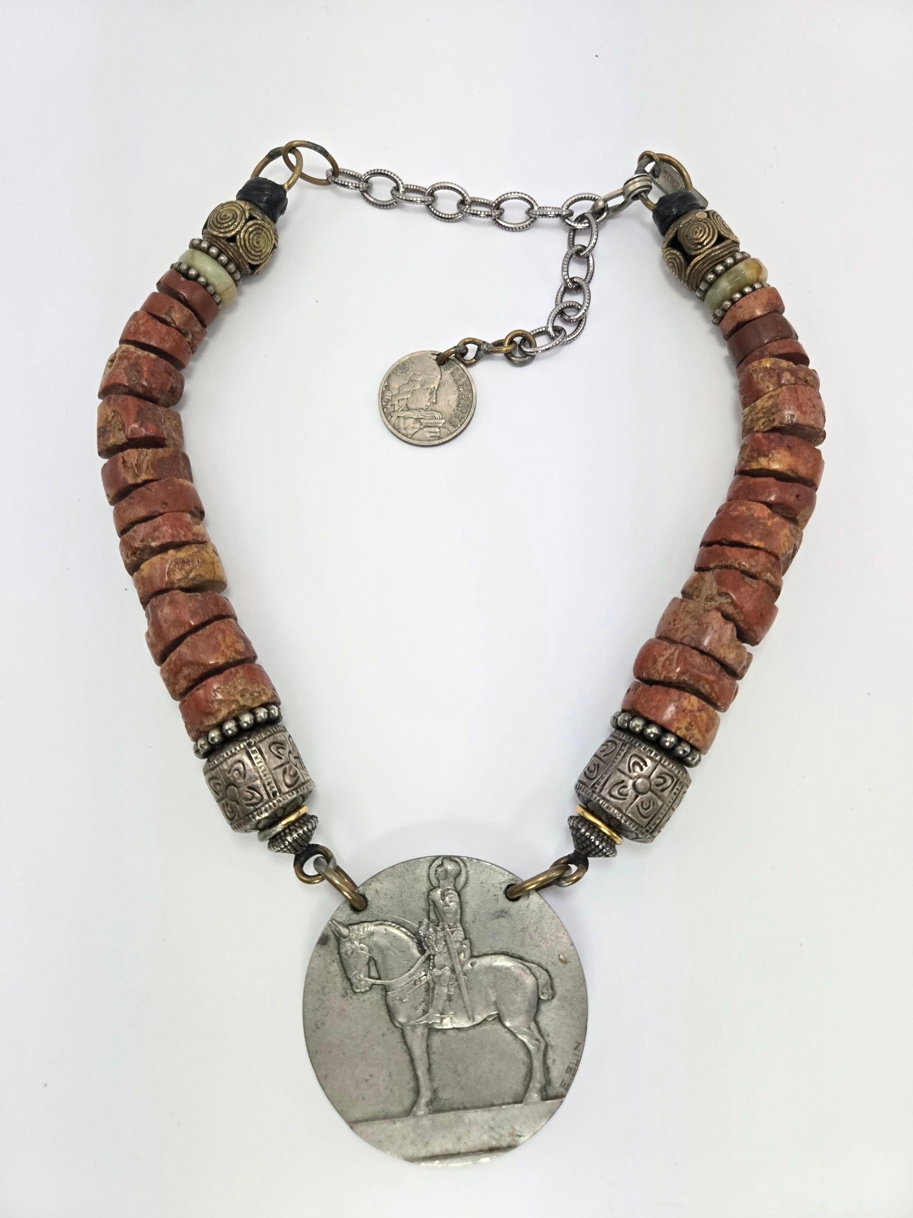 Masha Archer Joan of Arc Pendant Necklace with Bauxite and Silver Beads

The pendant is silver and is 2.25 inches in diameter, signed 
