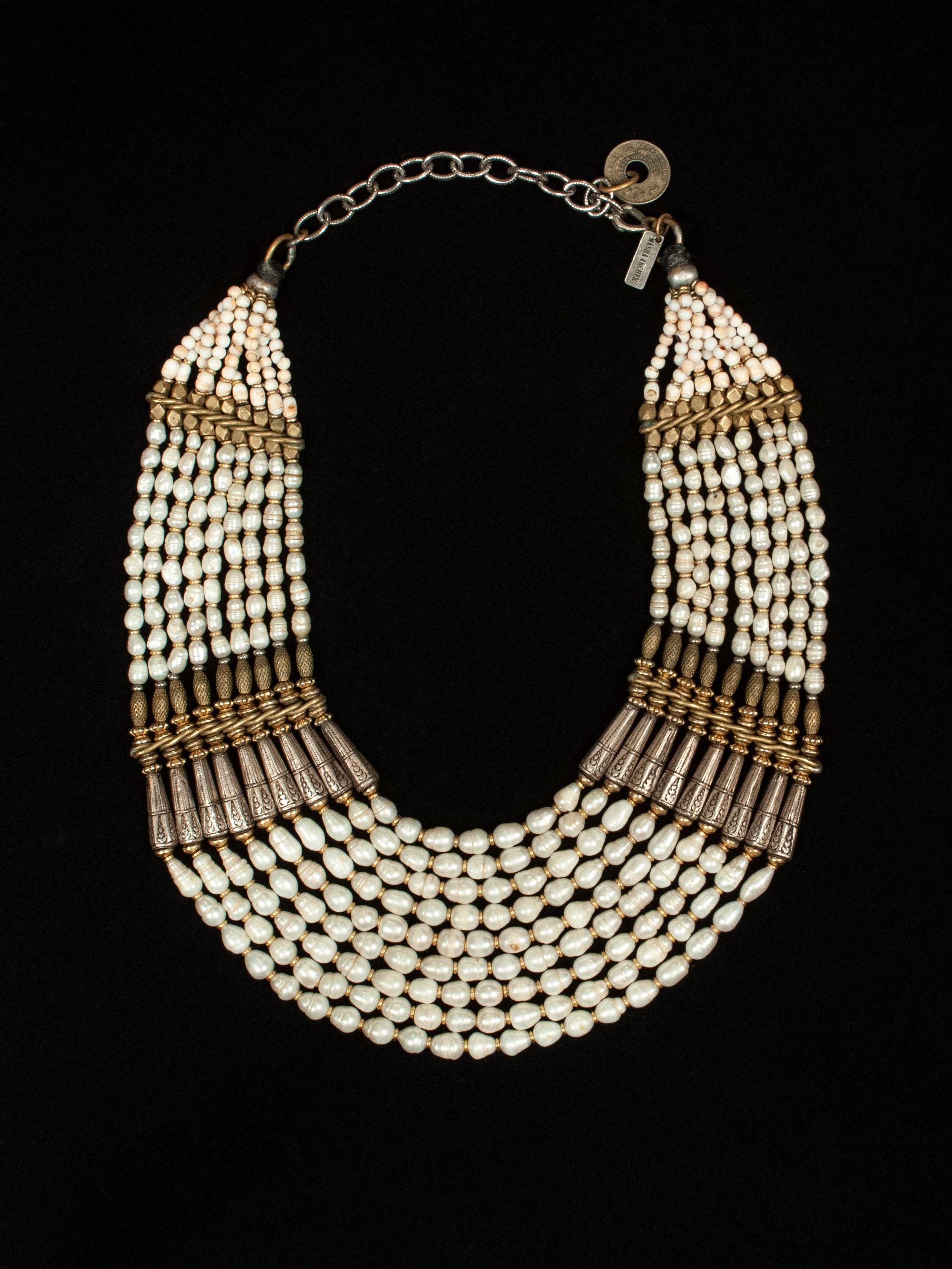 Masha Archer pearl bib necklace

A regal fresh water pearl necklace with brass and silver spacer beads from the famed San Francisco jewelry designer Masha Archer. The interior circumference measures from 16 - 20.5 inches, depending on where one