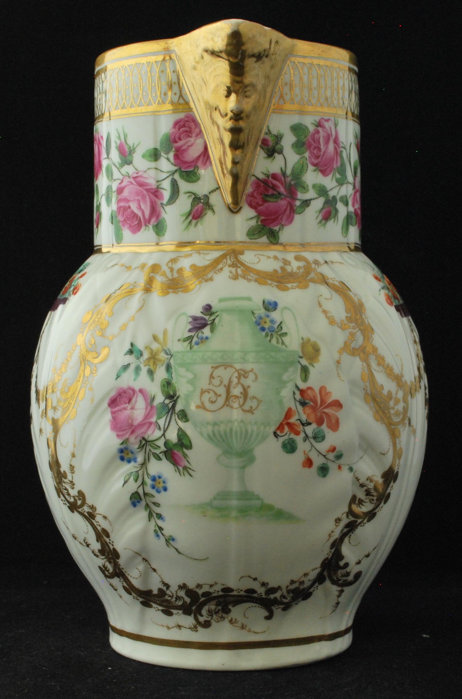 A Caughley cabbage jug with mask spout; decorated by Chamberlain Worcester with fine polychrome decoration and gilt intertwined initials. The decoration is particularly fine.
