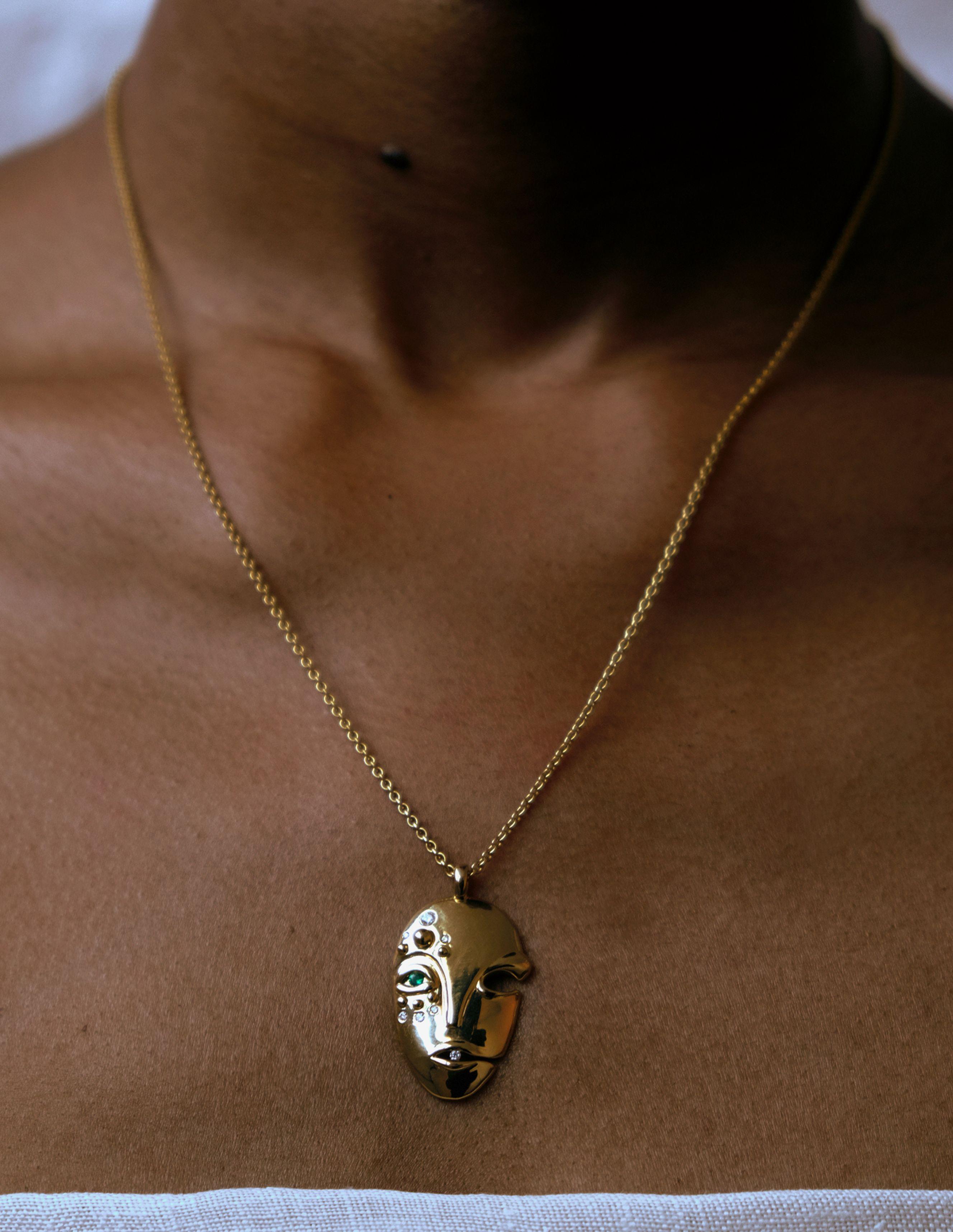 Sculptural Mask Pendant situating Brancusi’s modernity in conversation with West African sculptural tradition, featuring an eye set with a round cut emerald framed by graduated diamonds. 1.5 inch pendant on adjustable 18-20 Inch link chain with