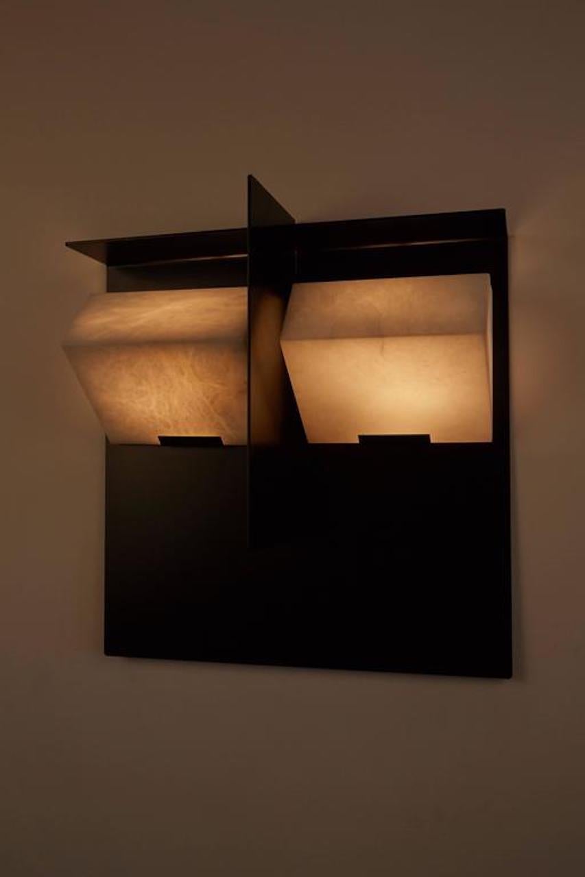 Designed in 1923, the rigorous geometry and single volume of this wall lamp reveal the mineral nature of alabaster and Pierre Chareau's minimalist choice, enhanced by the black metal / white alabaster contrast.
