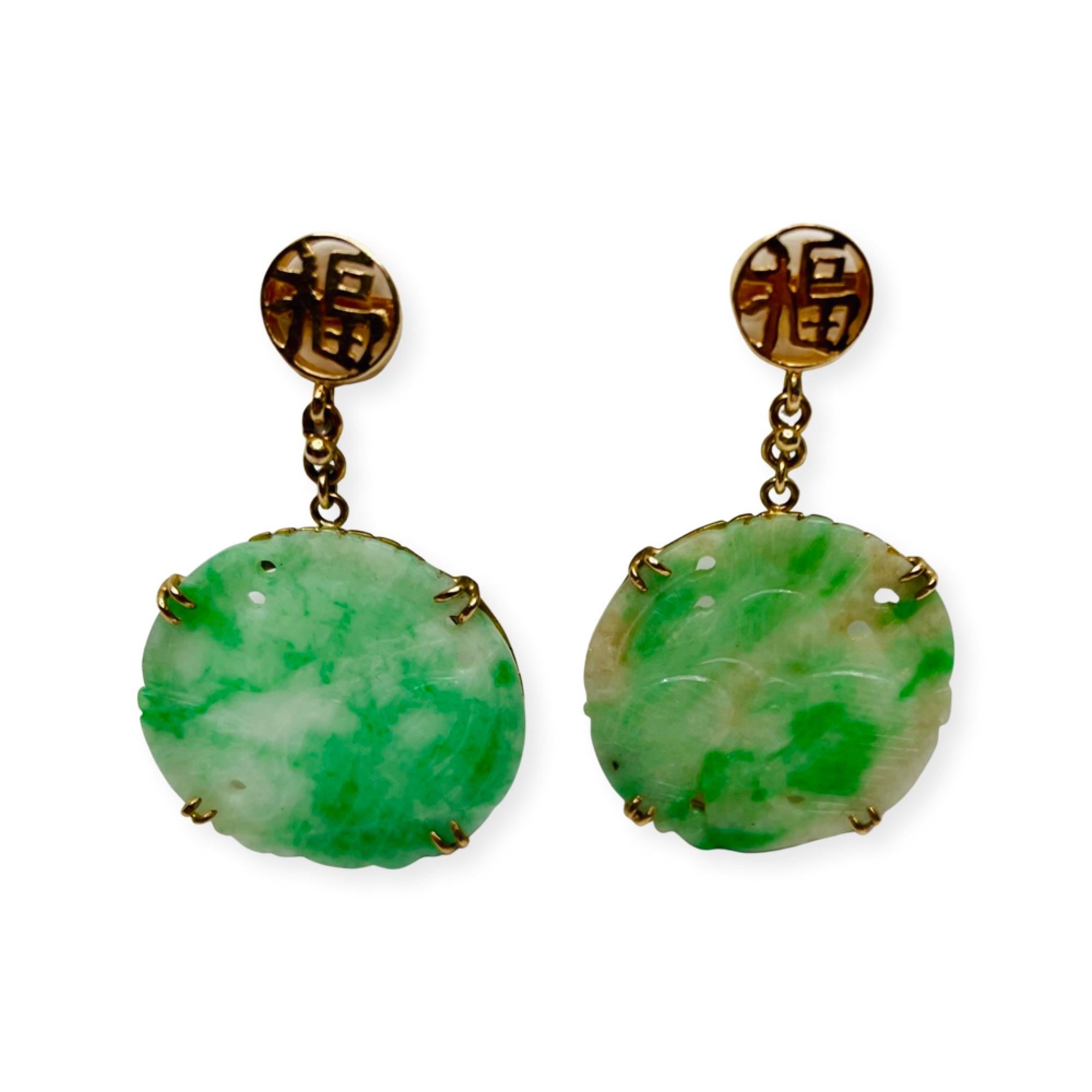 Mason Kay 14K Yellow Gold Natural Carved Green Jadeite Earrings. The carved antique, untreated jadeite discs measure 22.3 mm. They have a bird motive. They are set in 14K yellow gold frames and set with 4 double split prongs. The top of the jadeite