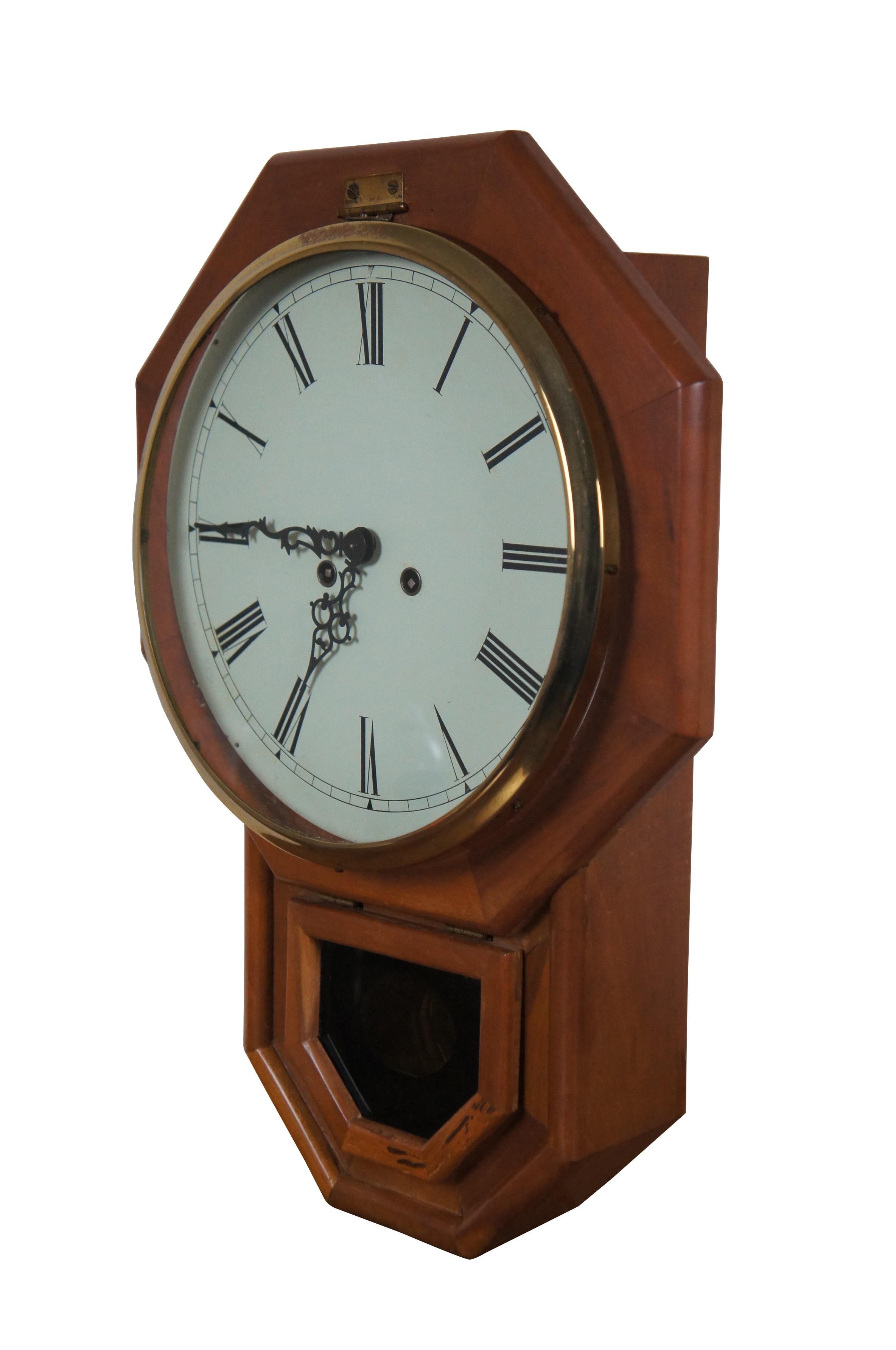 Reloj de pared con regulador, de principios a mediados del siglo XX, alemán, de 8 días, con cuerda de llave y sonería. Caja octogonal de madera con gota pentagonal para el péndulo. El péndulo de latón asoma por la ventana negra pintada al revés.