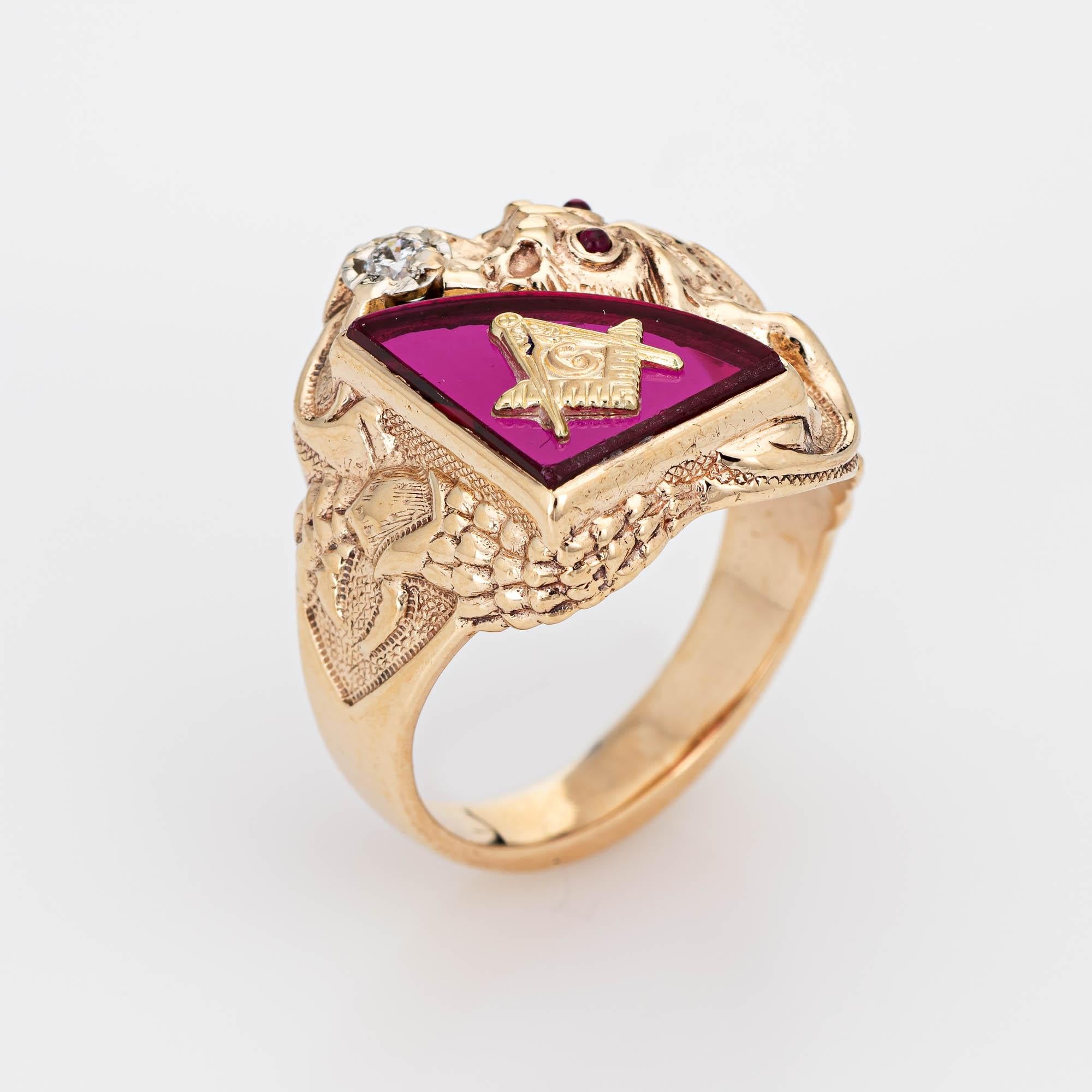 Finely detailed Masonic Lodge ring set with a diamond in a dragon motif, crafted in 10 karat yellow gold. 

One estimated 0.05 carat round brilliant cut diamond is set into the mount (estimated at H-I color and SI2 clarity). The red stone measures