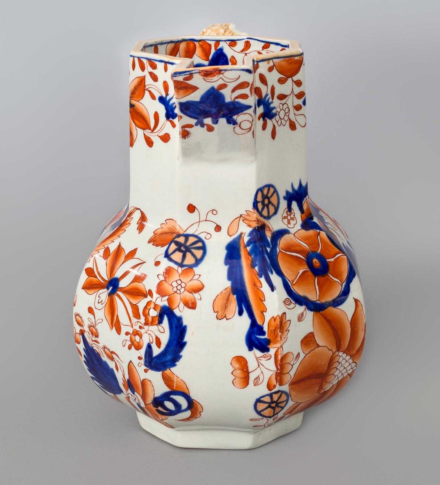 Mason’s Ironstone China Hydra jug with octagonal body, squared broad spout with long neck, sloping shoulders, bulbous shaped body, serpent handle, decorated in the Imari palette with large flowers and foliage. It is unmarked.