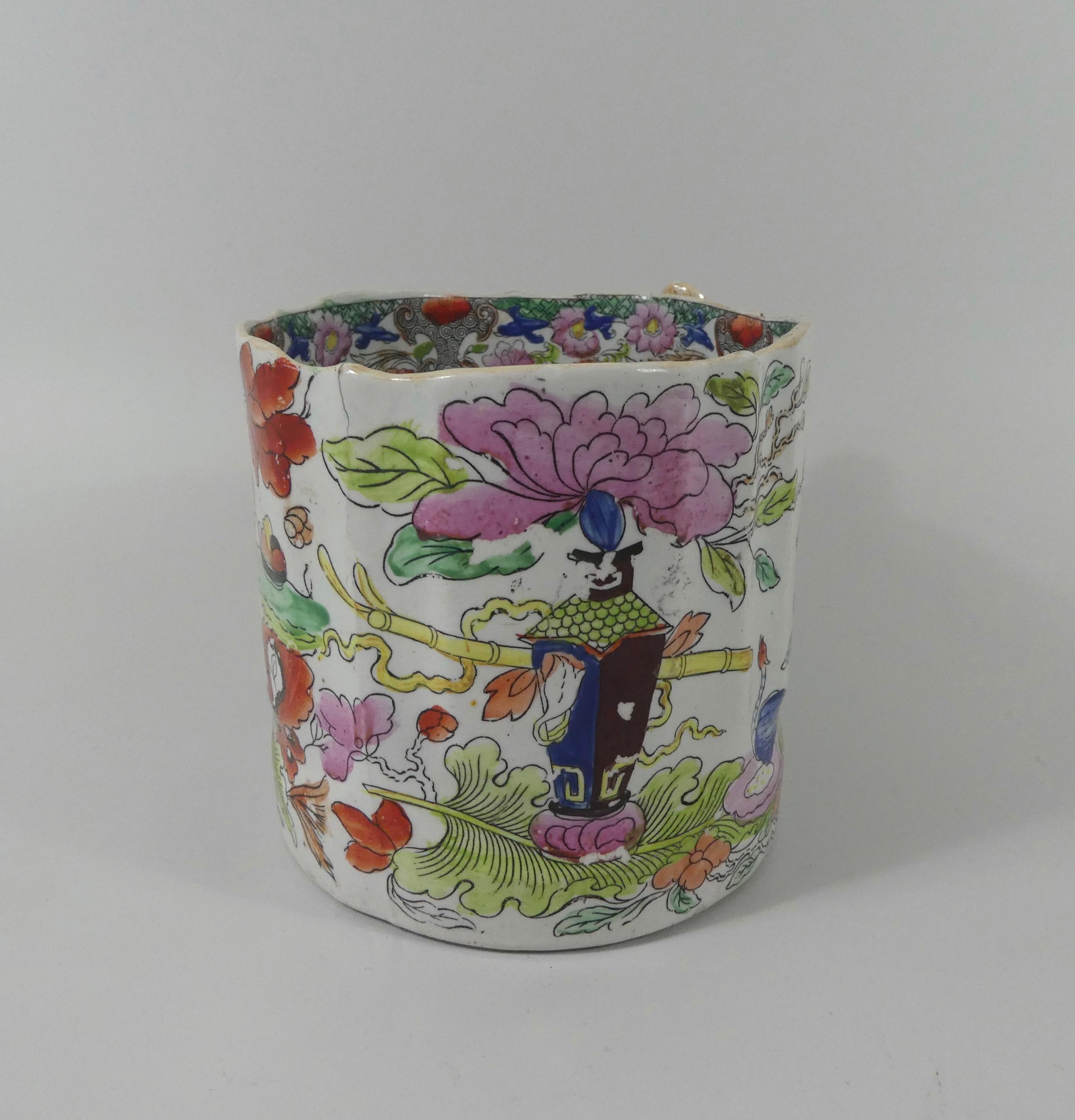 Masons Ironstone, a large cider mug, circa 1815. The over sized, moulded mug, printed and painted in the ‘Table and Vase’ pattern with a large vase, upon an artemisia leaf, next to an exotic bird, beneath flowering plants. The interior with a band