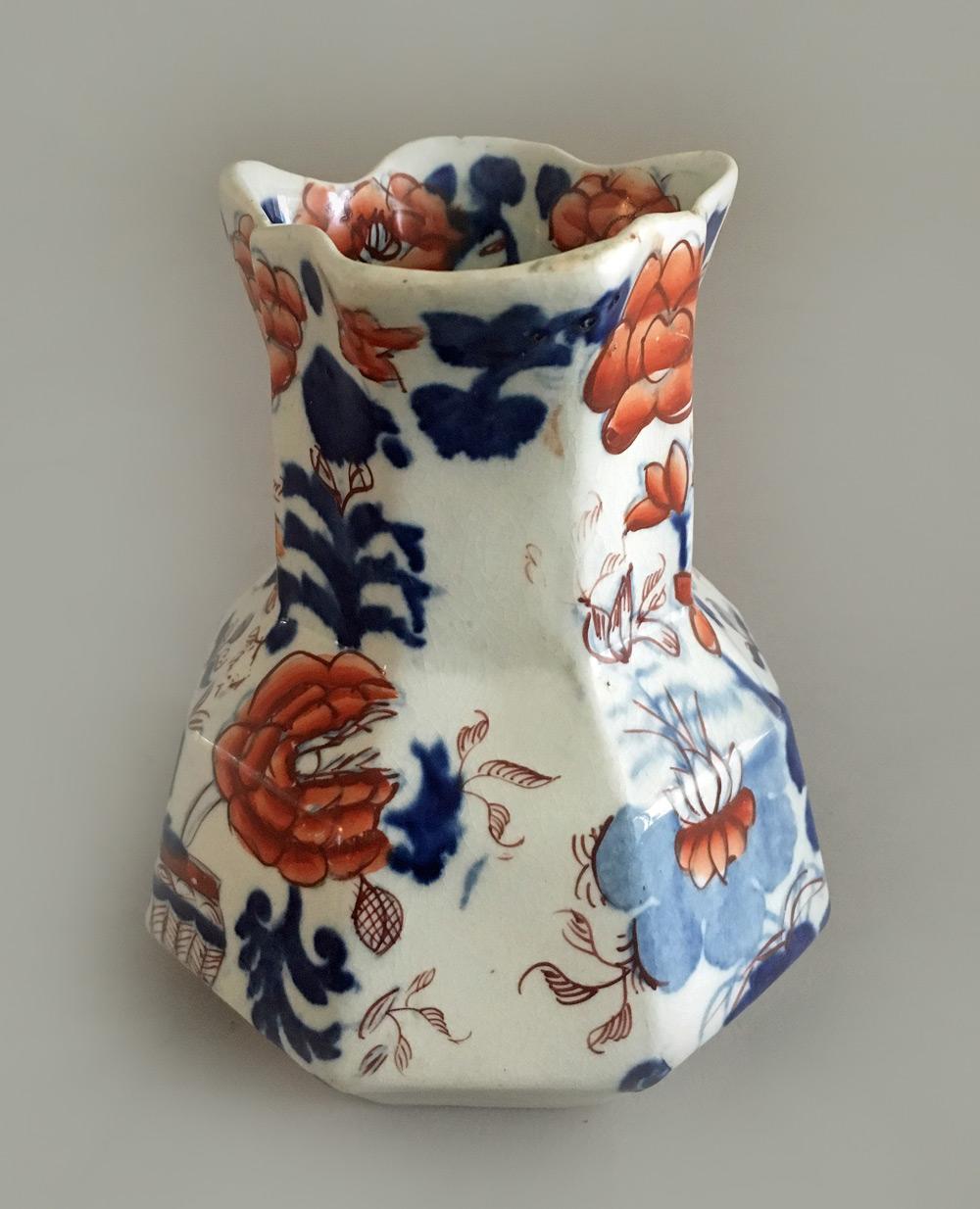Mason’s Ironstone small jug in the hydra shape with octagonal shaped body, broad spout, sloping shoulders and bulbous body with a serpent handle. It is decorated with large flowers in cobalt blue and iron red. The bottom has the Mason’s Ironstone