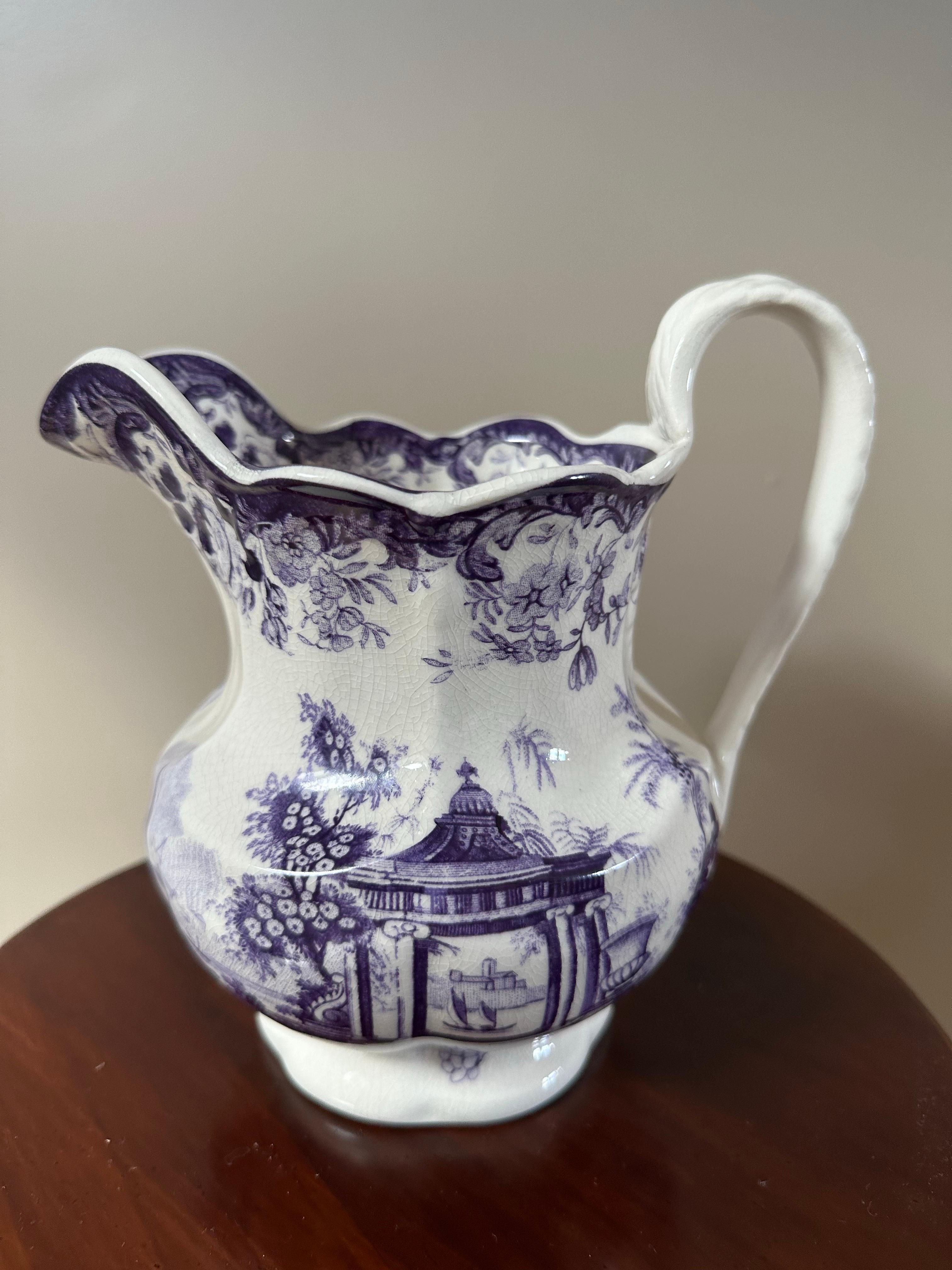 Questa antica brocca inglese in pietra di ferro mette in mostra la bellezza e la maestria delle ceramiche inglesi dell'inizio del XIX secolo. Realizzata in resistente ceramica vetrosa, la pietra di ferro fu brevettata per la prima volta nel 1813 con