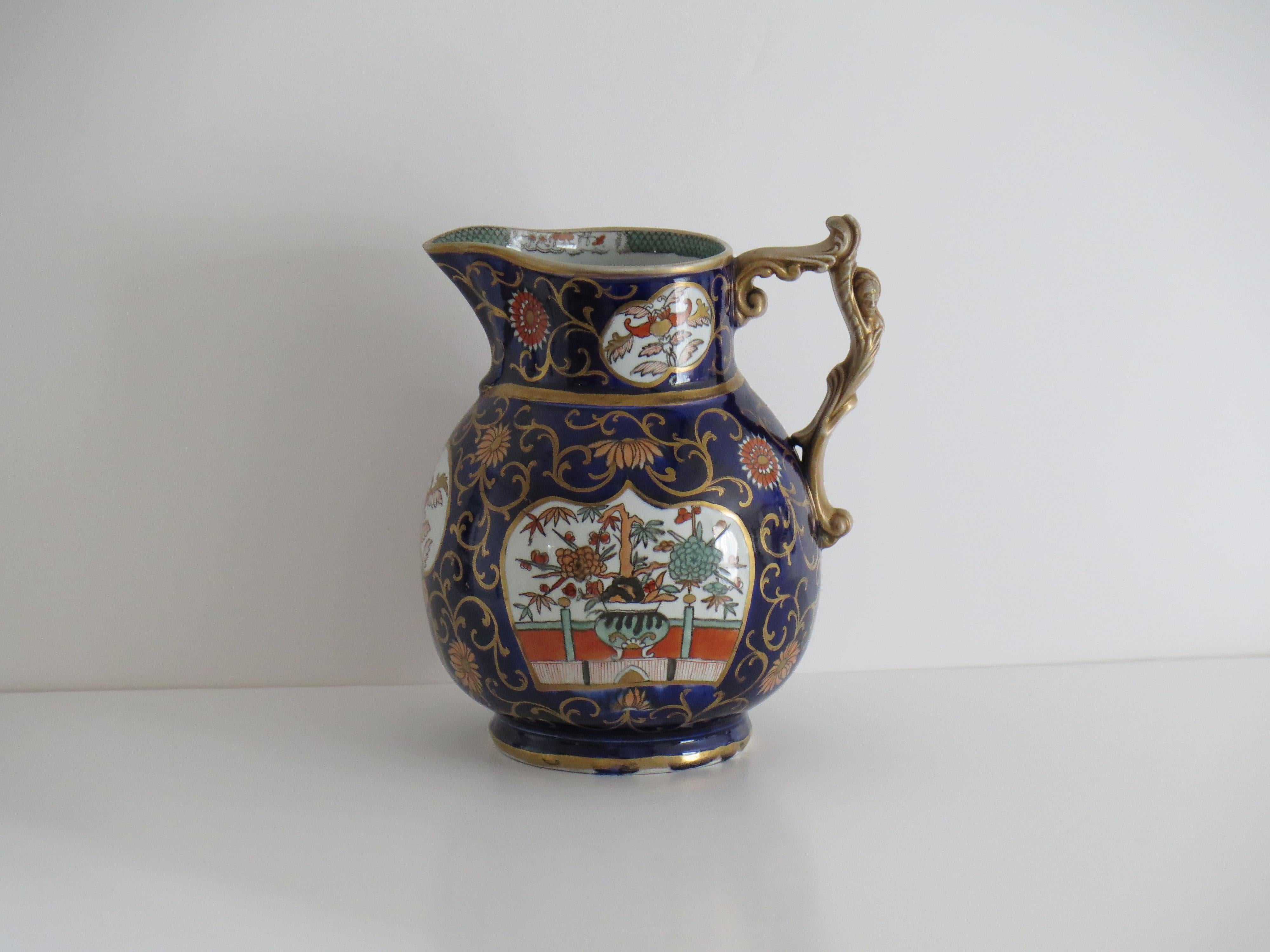Si tratta di una grande brocca in pietra ferrosa con il motivo Blue Hawthorne e Fence & Bowl, realizzata da Mason's Ironstone di Lane Delph, Staffordshire, Inghilterra, durante la prima metà del XIX secolo, circa 1825-1835.

Questa grande brocca ha