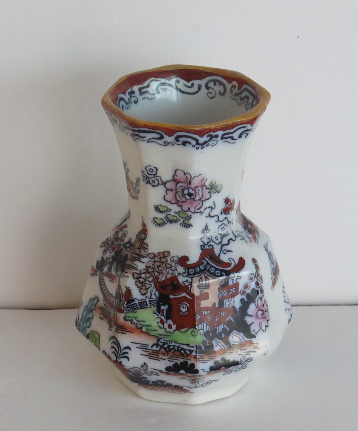 This is a good spill vase or beaker made by Mason's ironstone, Lane Delph, England in the mid 19th century, circa 1850.

The pattern is called Japan Willow an would have been transfer printed with over-glaze hand painted bold enamels. 

The vase