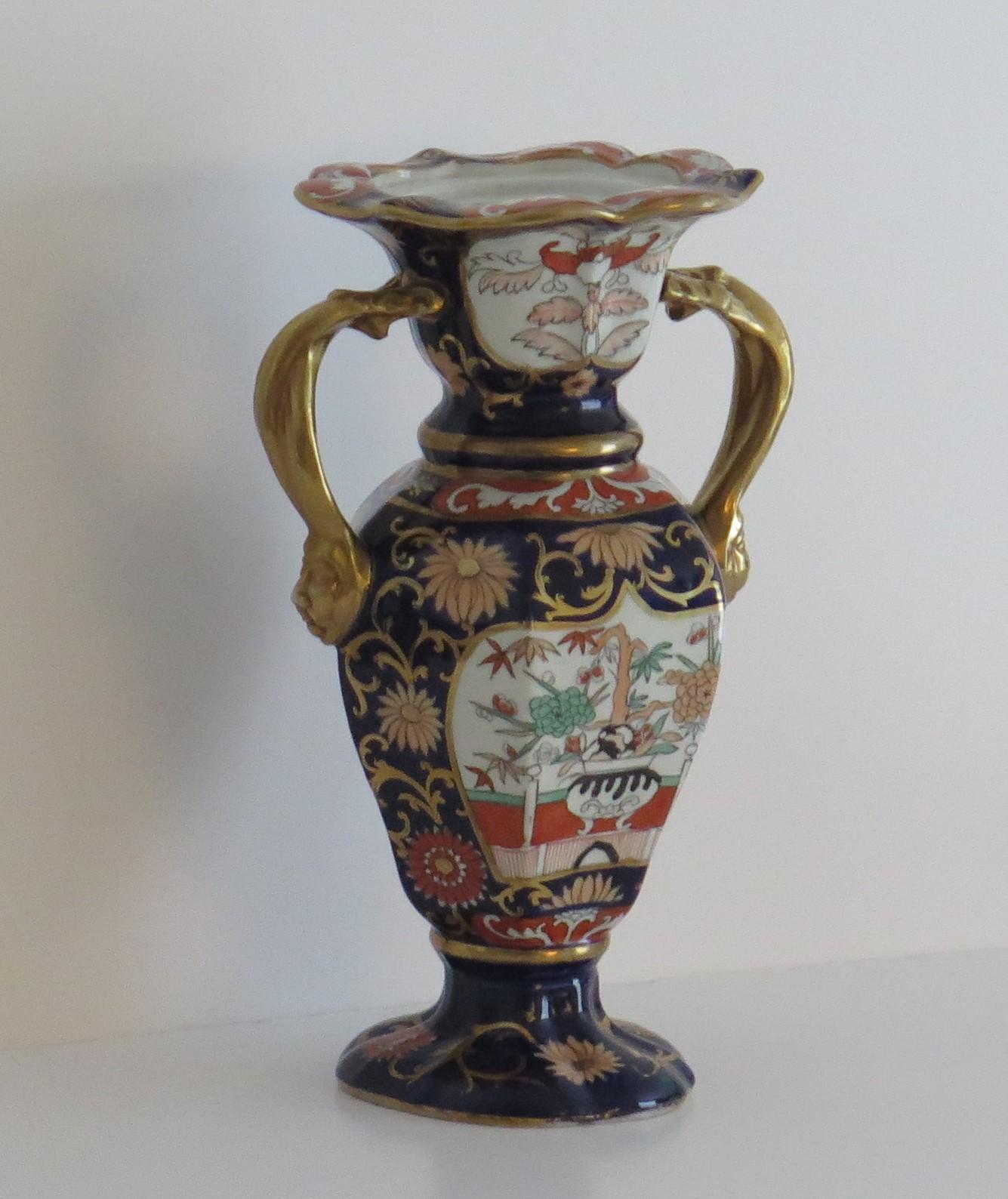 This is an ironstone tall Vase in the blue Hawthorne and fence and bowl pattern, made by Mason's Ironstone of Lane Delph, Staffordshire, England, during the first half of the 19th century, circa 1825-1835.

The vase has a fairly rare shape, with a