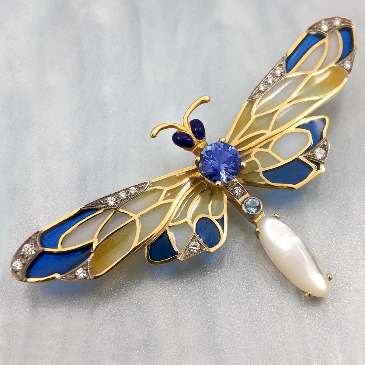 This stunning Masriera 18-karat yellow gold Dragonfly brooch/pendant has blue,white,and yellow plique-à-jour enameling on its wings.It is delicately detailed with brilliant-cut diamonds, a round blue sapphire,a round aquamarine, and a marquis shaped