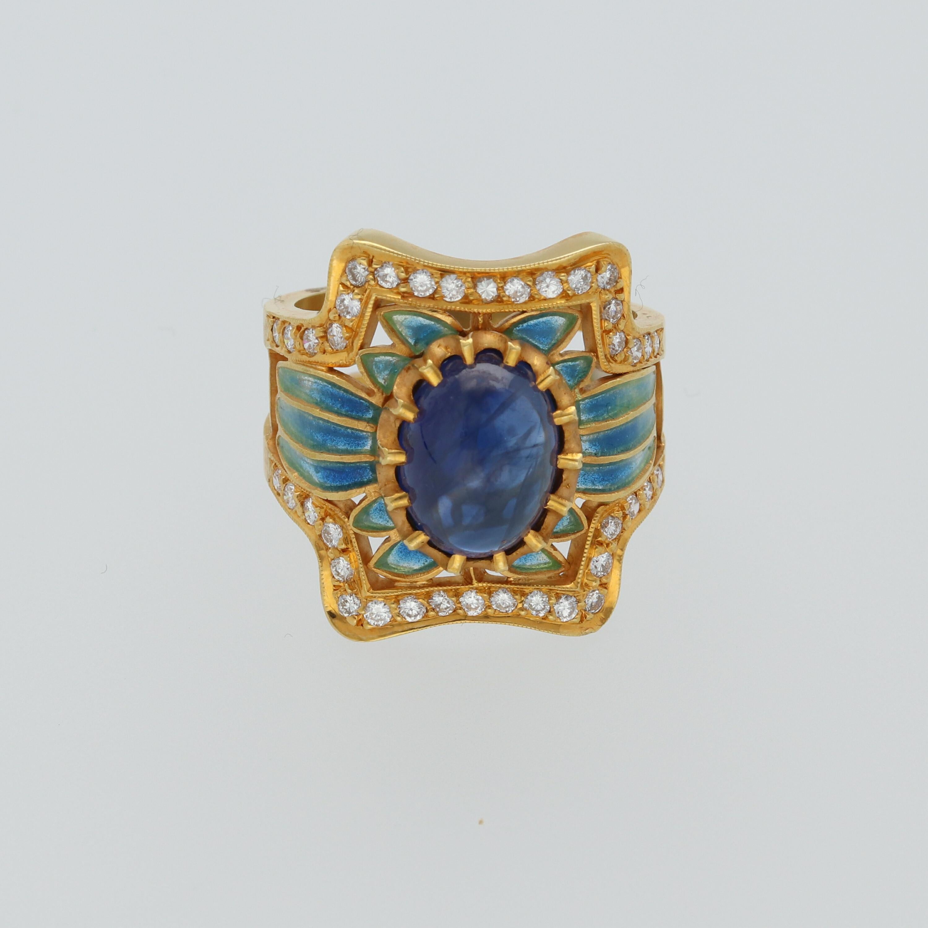 A Masriera Modernist fashion ring, set with a blue sapphire cabochon, weighing 3.8 carats, centered in a naturalistic plique-à-jour enamel, accented with circular-cut diamonds, weighing 0.57 carats, mounted in 18K yellow mat gold.

Size EU 52.5 -