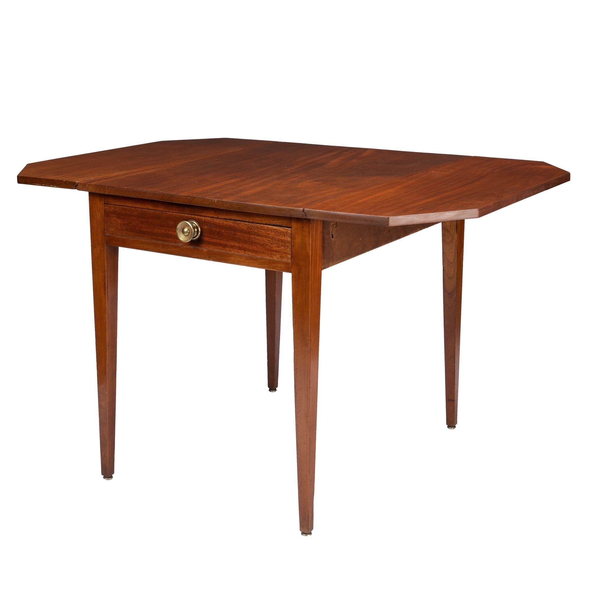 American Hepplewhite drop leaf Pembroke table in Honduran mahogany with a wide rectangular single board top on a conforming apron with four square tapered legs. The apron is fitted with a single drawer with brass drawer pull in the original boring.