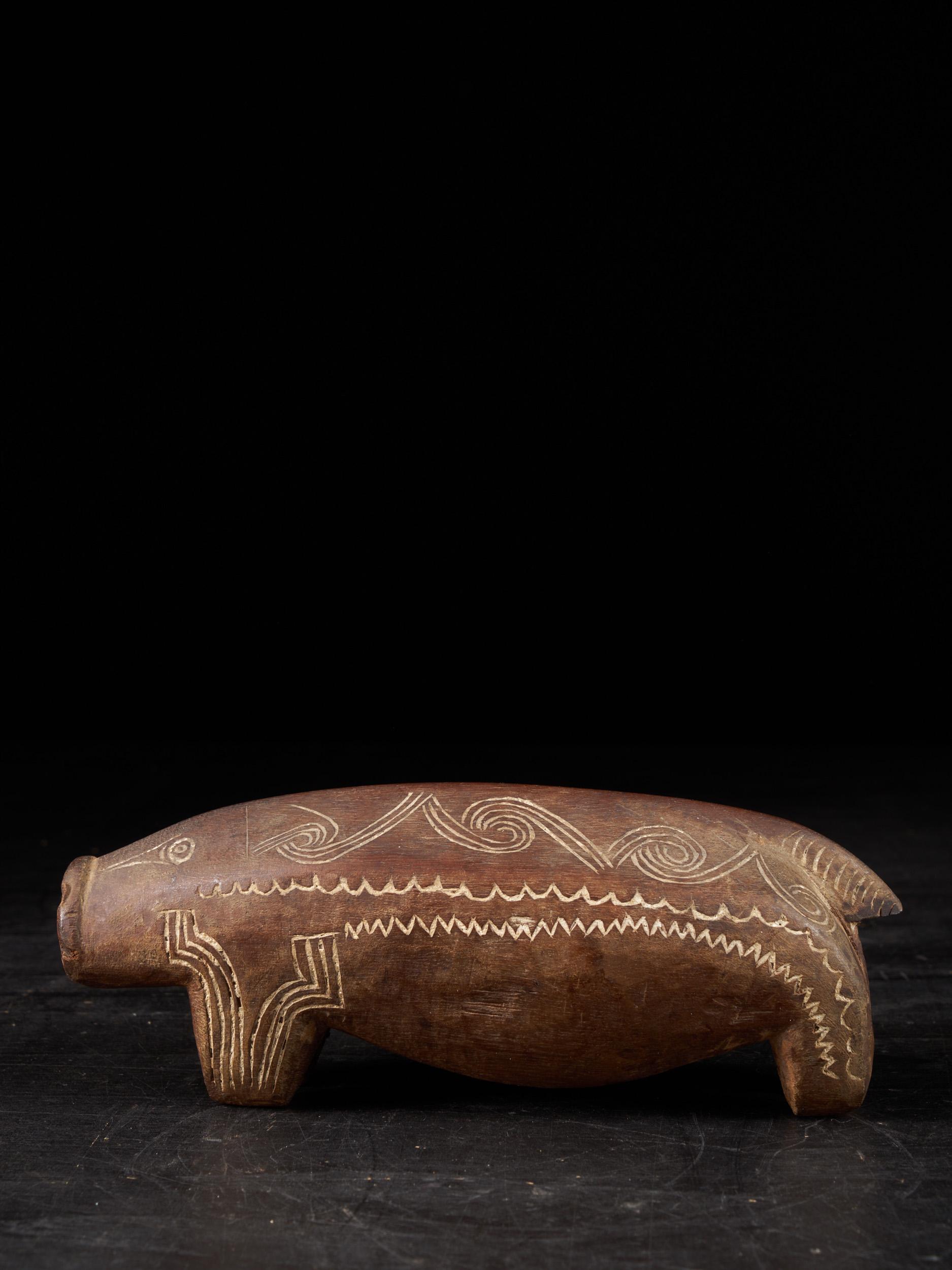 Late 19th to early 20th century New Guinea, Trobriand Islands, Milne Bay, Massim People carved wooden pigs with incised decoration and flat paddle-style tails. The National Museum of Australia holds about 24 of these pig carvings from this era,