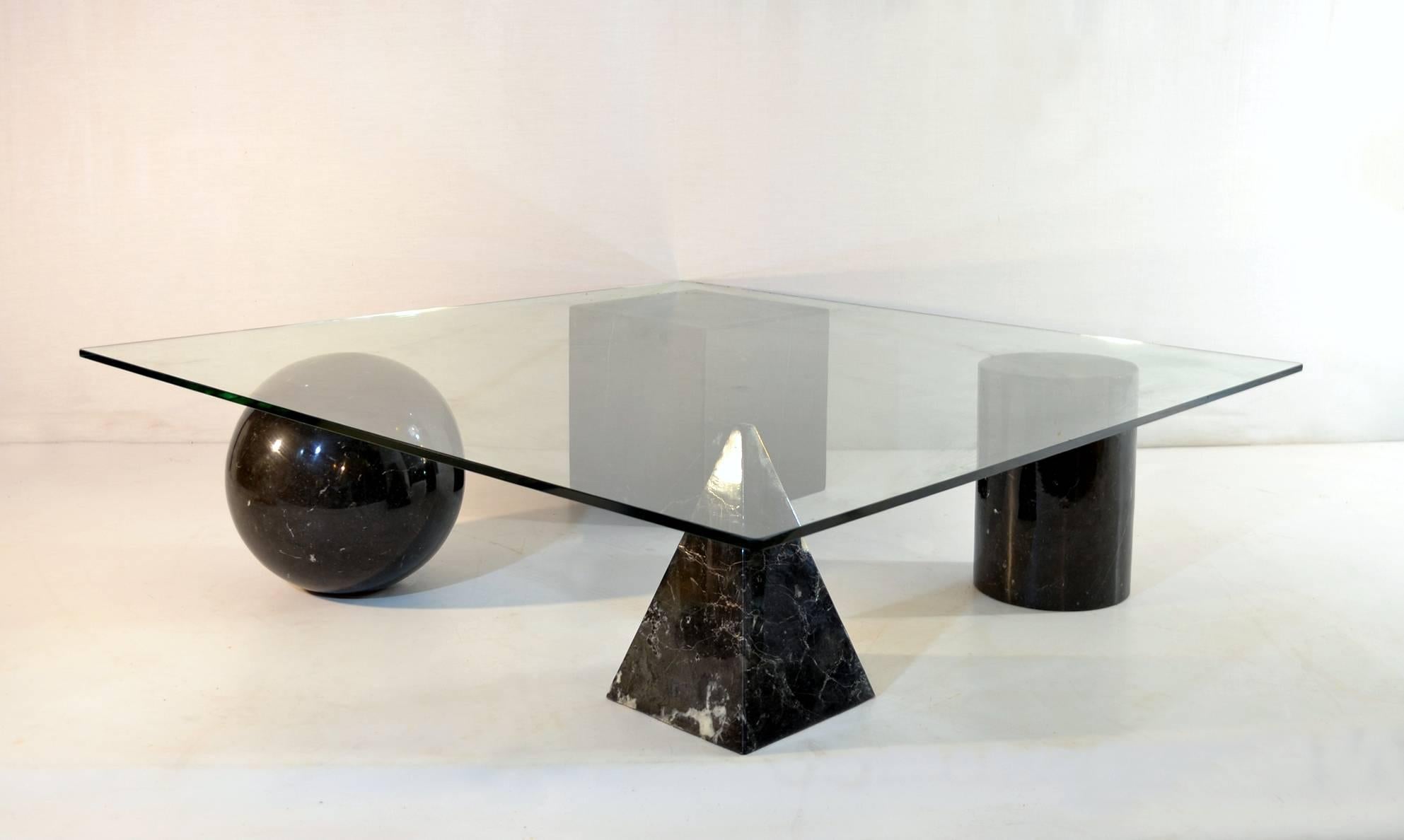 Metafora cocktail table designed by Lella and Massimo Vignelli for Martinelli Luce. The four geometric shapes, a cube, a cylinder, a ball and a pyramid are made in black marble with white veins.