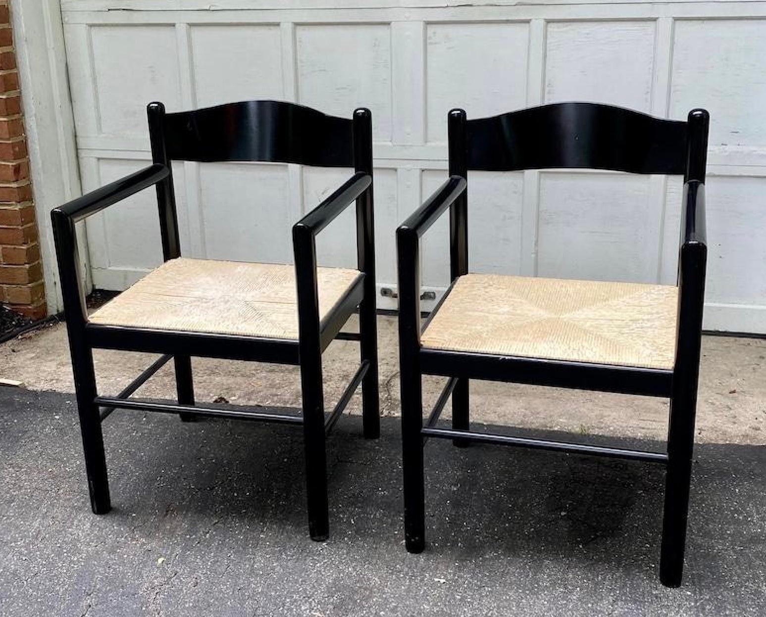 A pair of stunning black lacquer ebonized acorn armchairs or dining chairs designed by Massimo and Lella Vignelli. These mid-century modern chairs, crafted in Italy, boast a birch frame with rounded arms, supports, and legs. The seat is generously