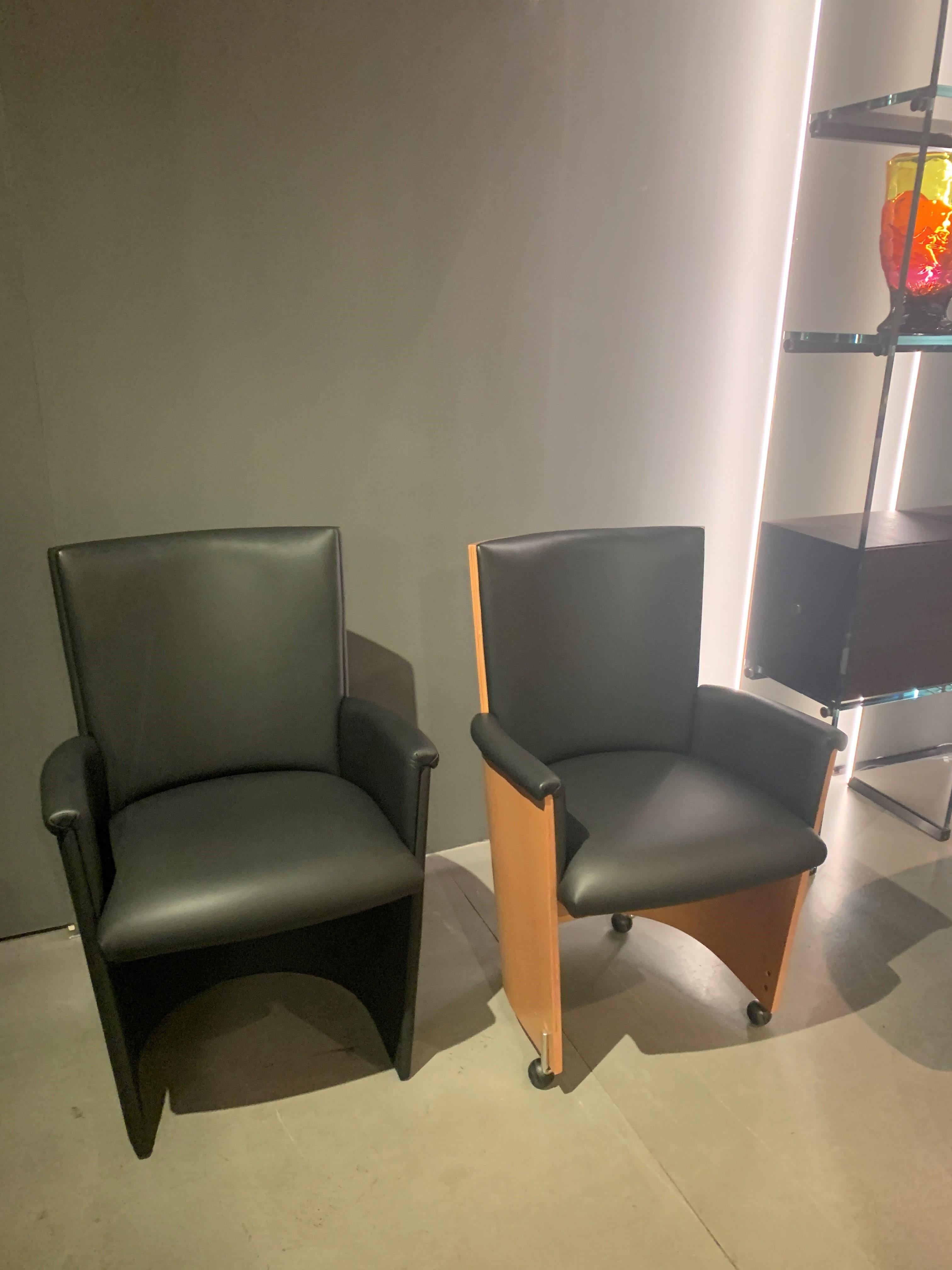Ein Sessel aus schwarzem Leder mit einer Oberfläche aus Walnussholz. Entworfen von Massimo und Lella Vignelli für Bernini. Ein Satz von 4 Rollen an der Unterseite.