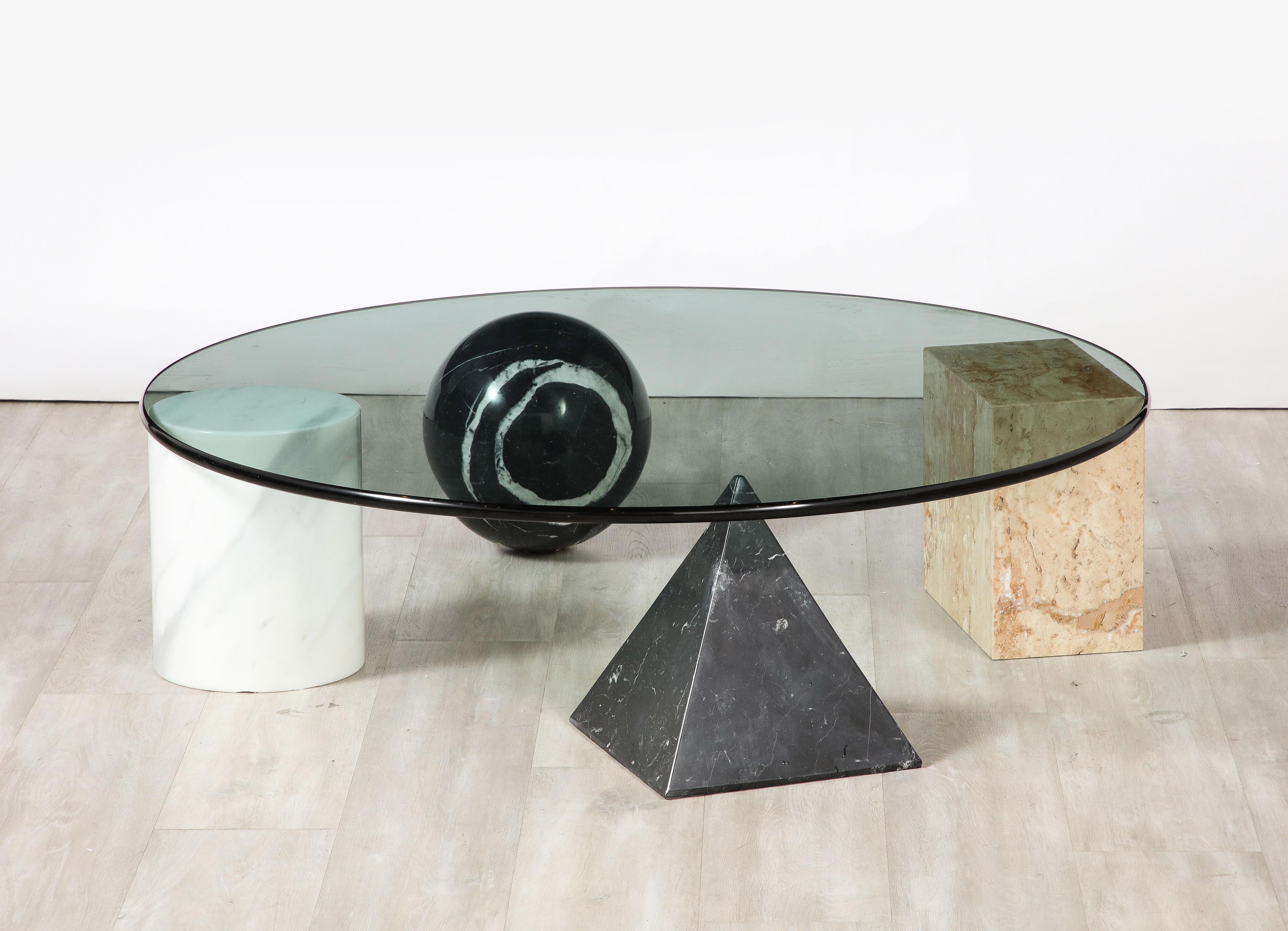 'Metafora' coffee table by Massimo and Lella Vignelli, 1979 

The coffee table support with four forms of the Euclidean geometry; all in solid marble: a cube, cylinder, sphere and a pyramid. The four elements are independent and can be positioned