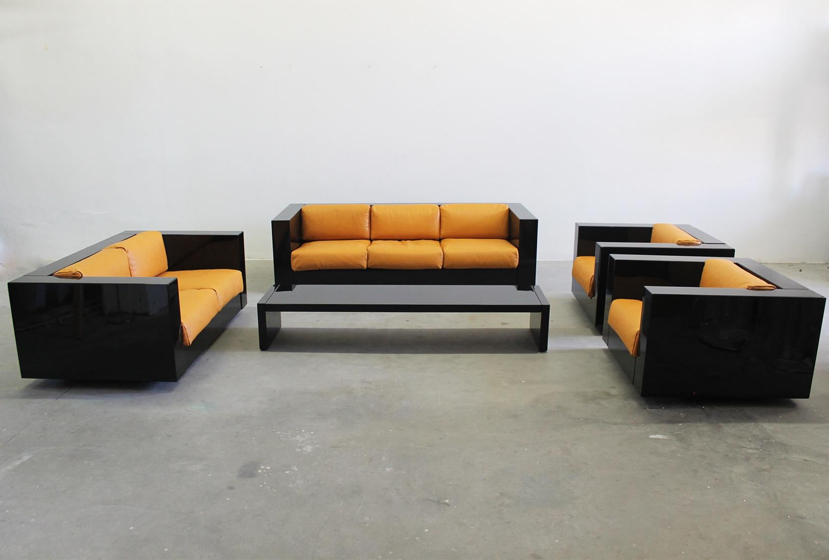 Saratoga living room set composed by a three-seater sofa, two-seater sofa, two armchairs and a low table with a structure in black lacquered wood, padded leather cushions and metal details. 

Designed by Massimo and Lella Vignelli and produced by