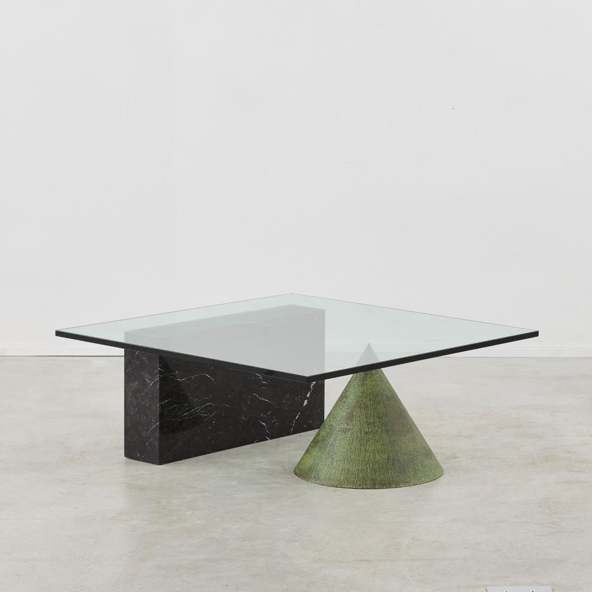 A sculptural Kono coffee table designed by Lella and Massimo Vignelli. A thick sheet of glass appears to precariously balance on a copper cone and marble block, however this illusion is far from the truth. Cleverly designed, taking inspiration from